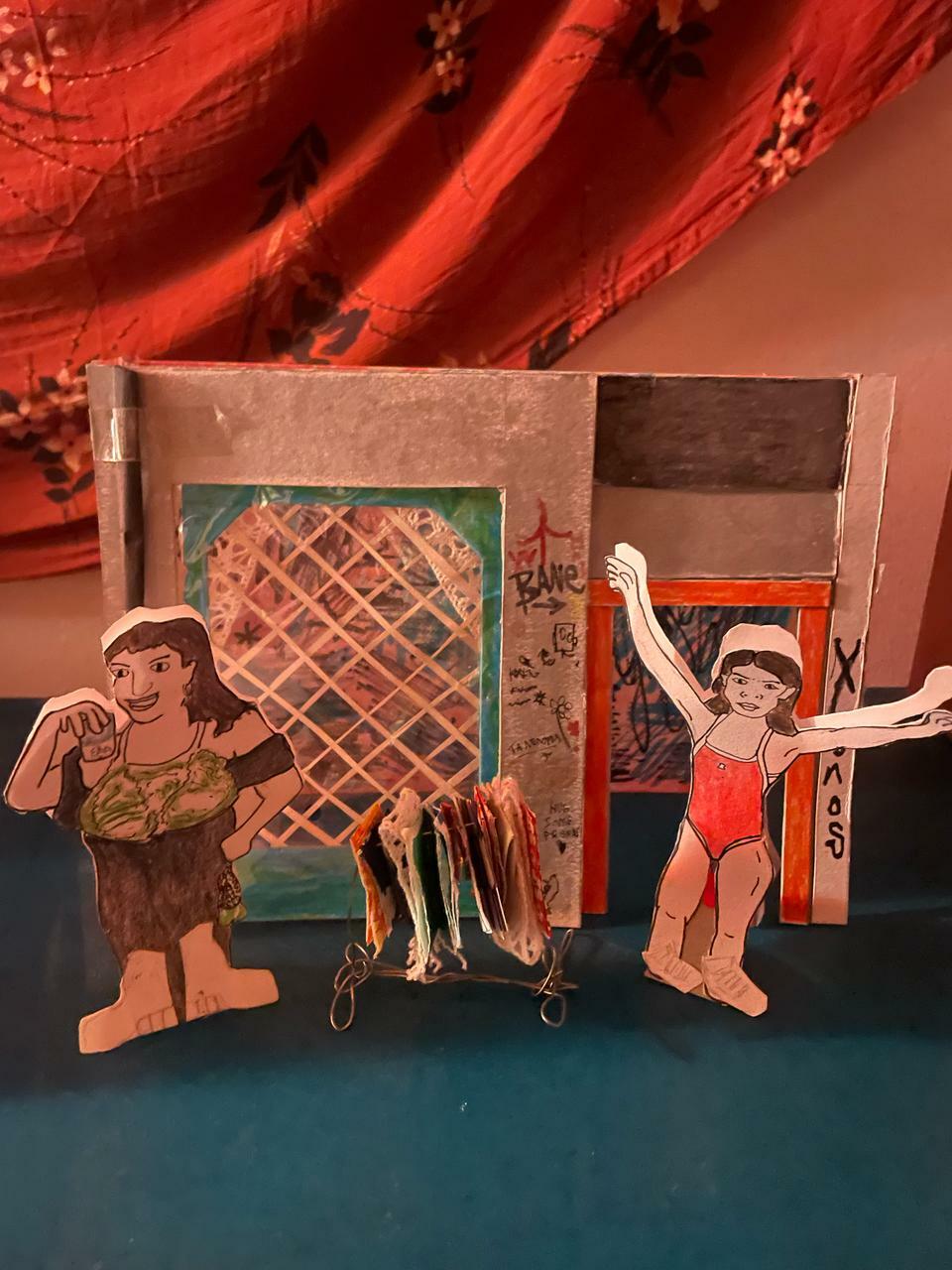 Vintage paper dolls and accessories on a colourful background with red and orange tones.