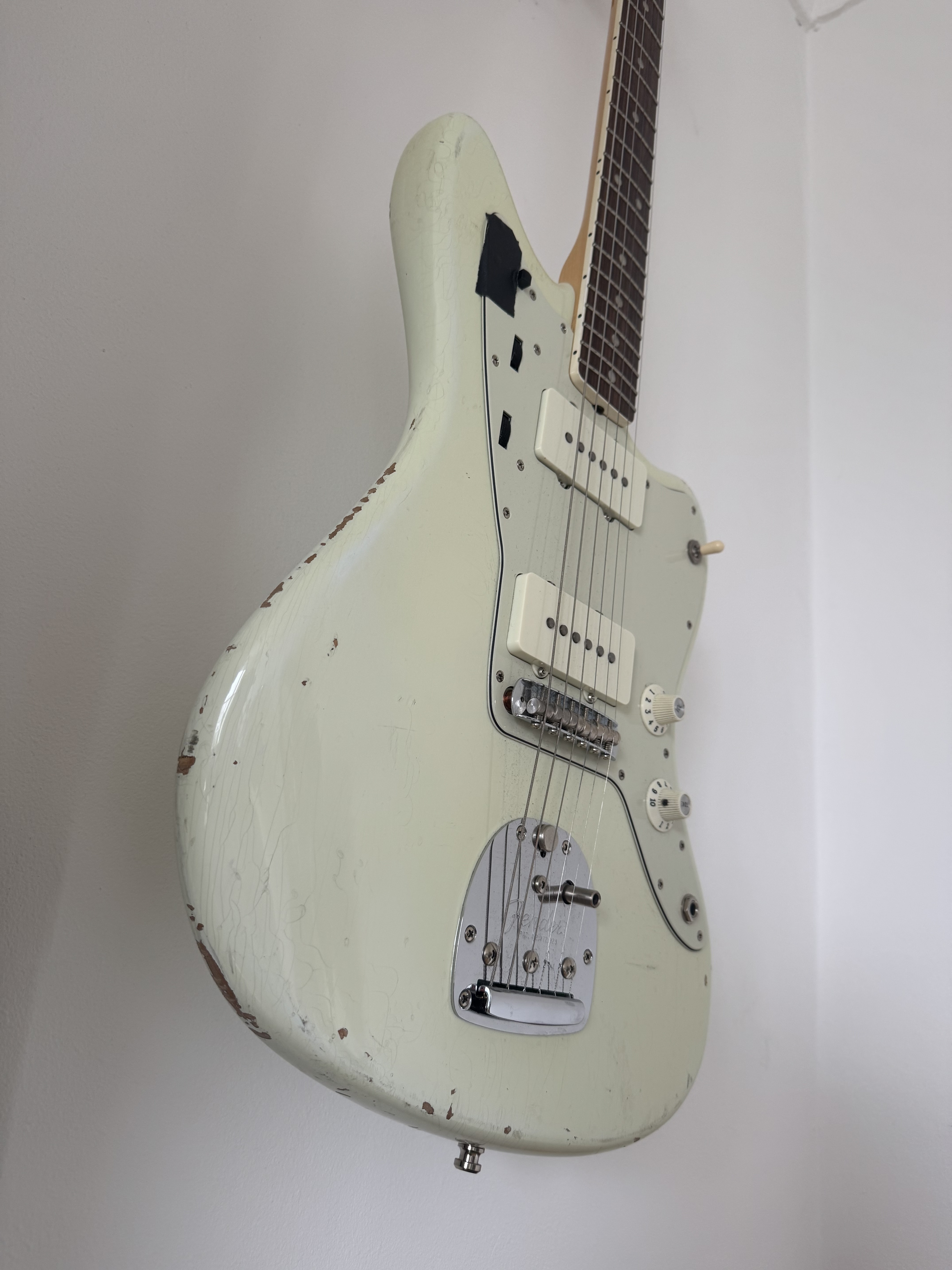White electric guitar with black detailing and hardware.