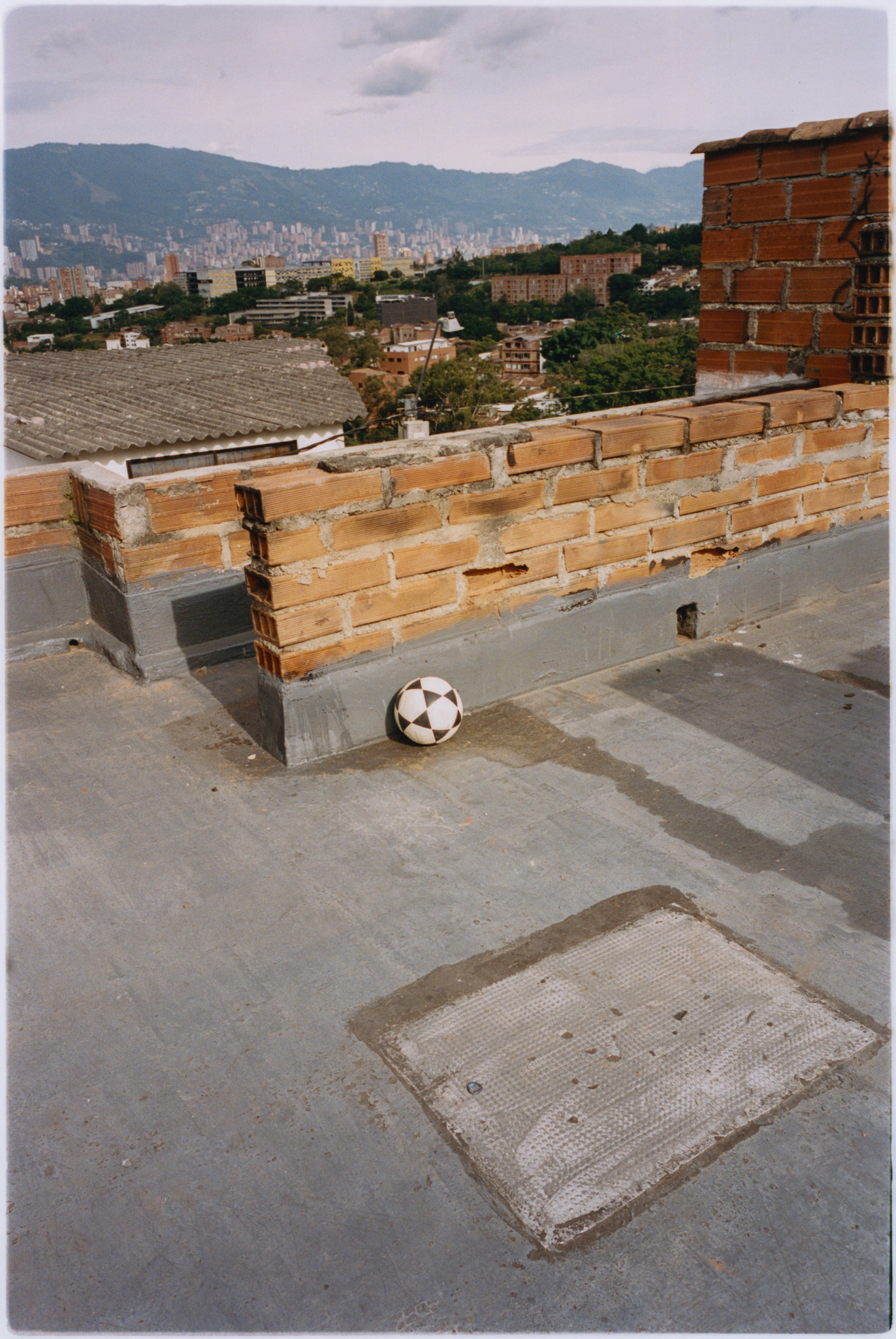 Urban landscape with brick walls, concrete floor, and a football on the ground.