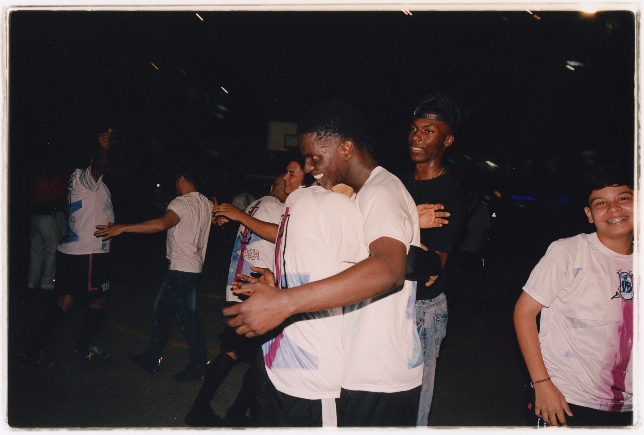 Young people dancing together at a nightclub in dim lighting.