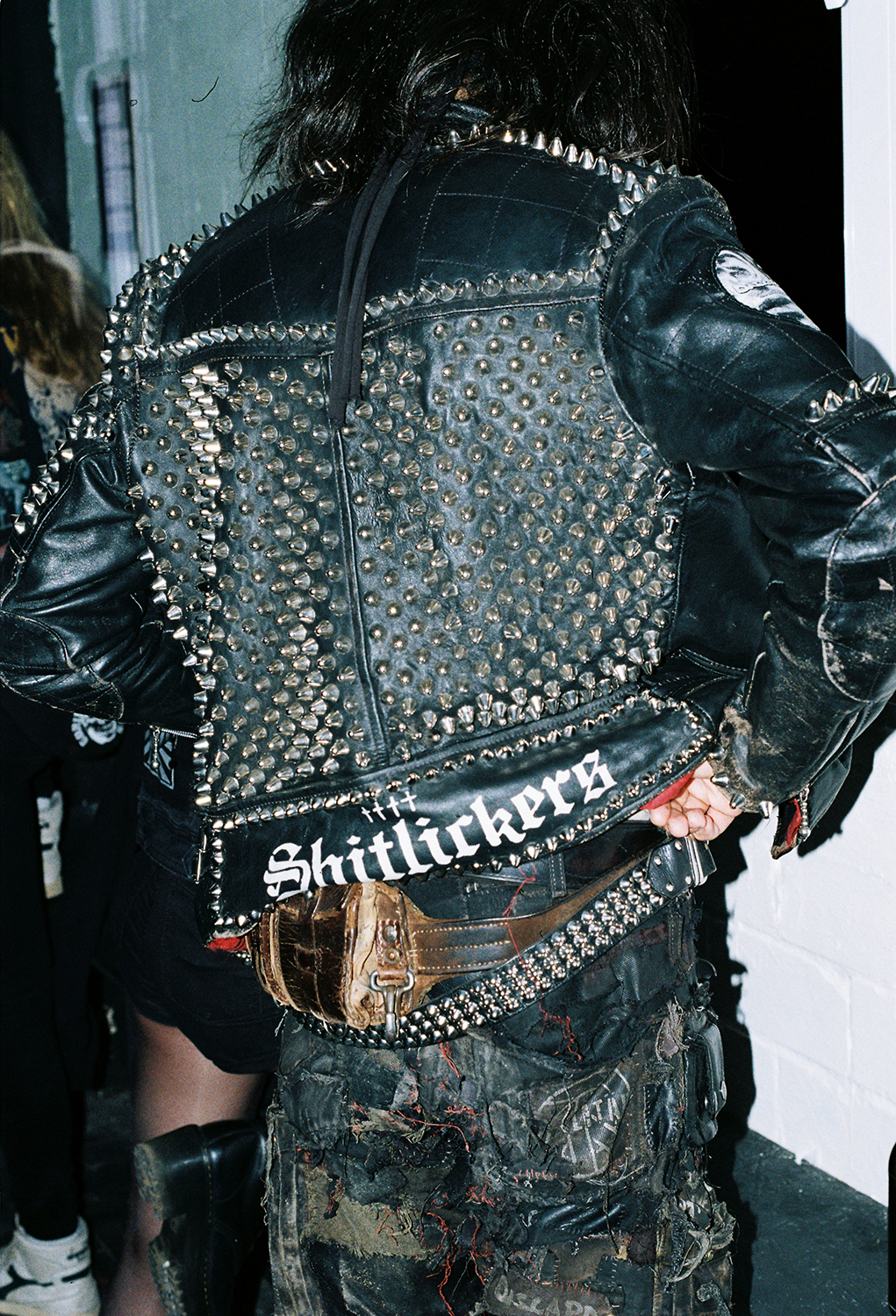 Studded black leather jacket with 'Shitlickers' text