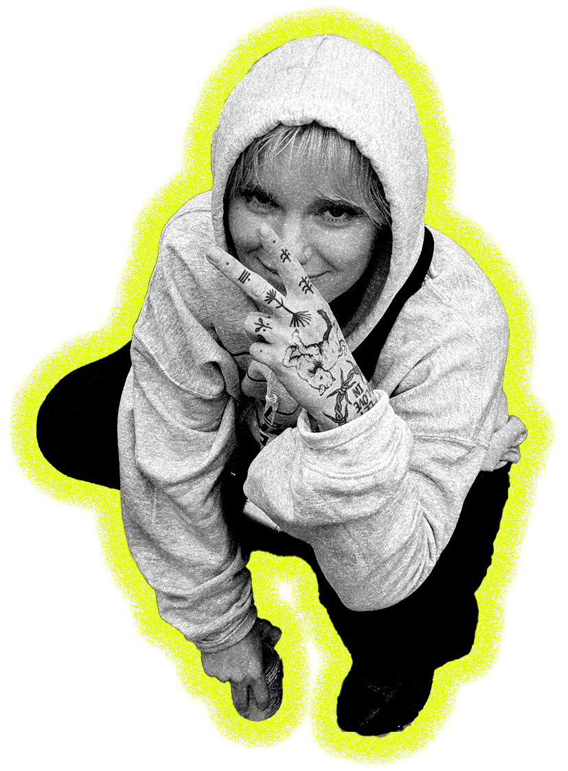 Black and white portrait of person in hooded jumper with tattooed hand, outlined with bright yellow-green border on black background.