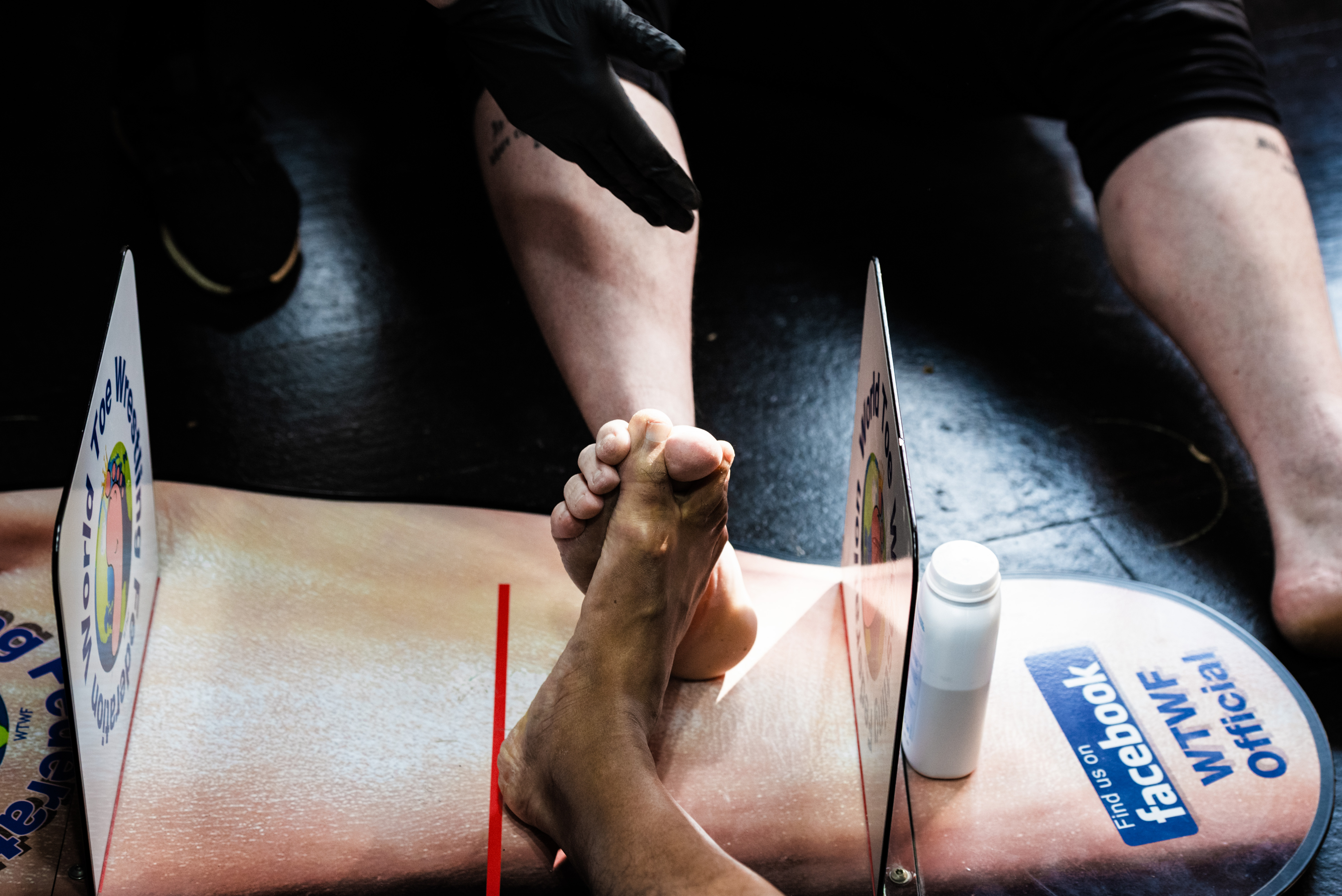 Image of a person's hand and arm holding medical equipment, including a thermometer and a syringe. The forearm appears to be resting on a blue and white medical form or document.