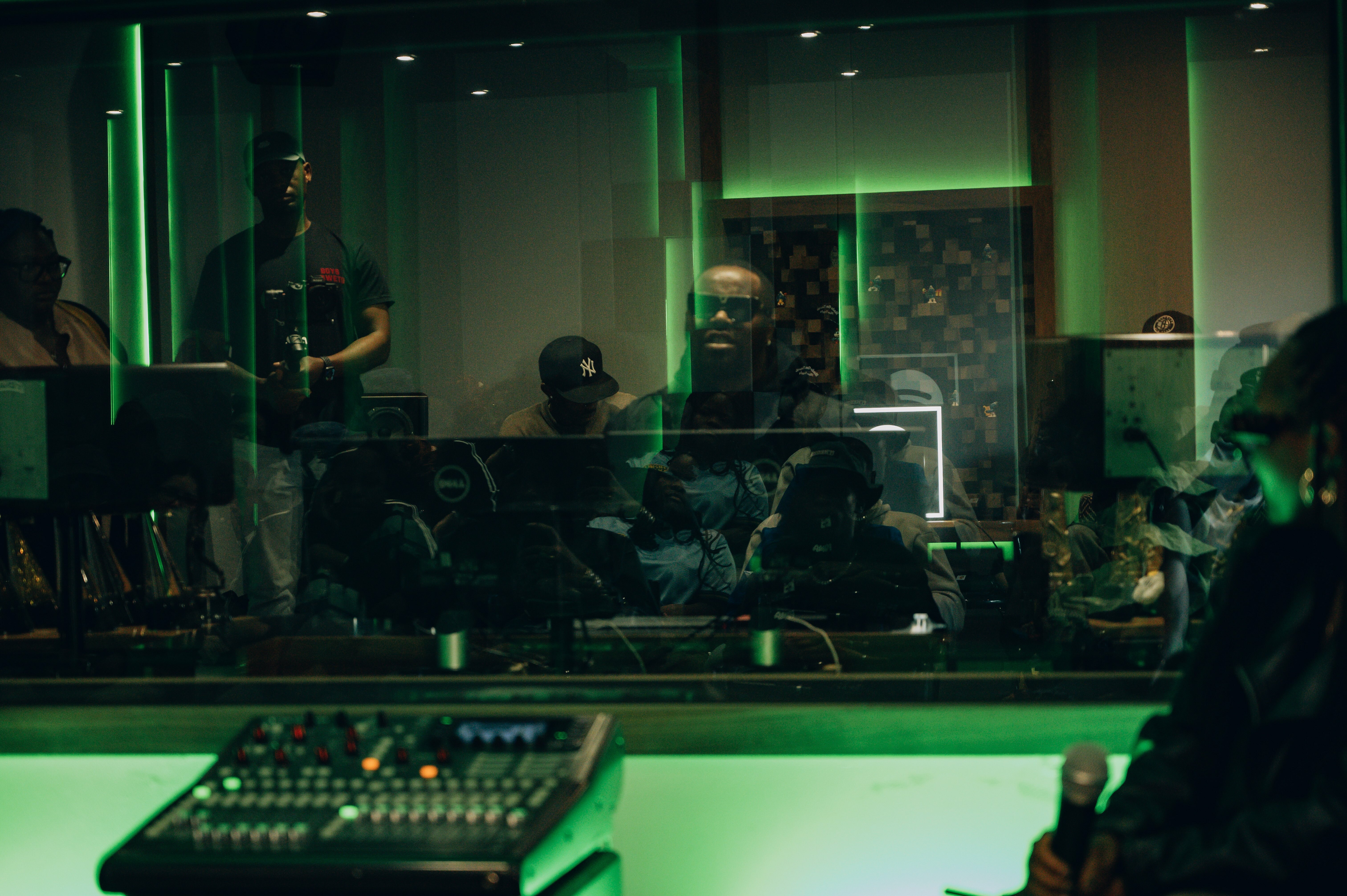 Dark room with stage and sound equipment, dominated by green lighting.