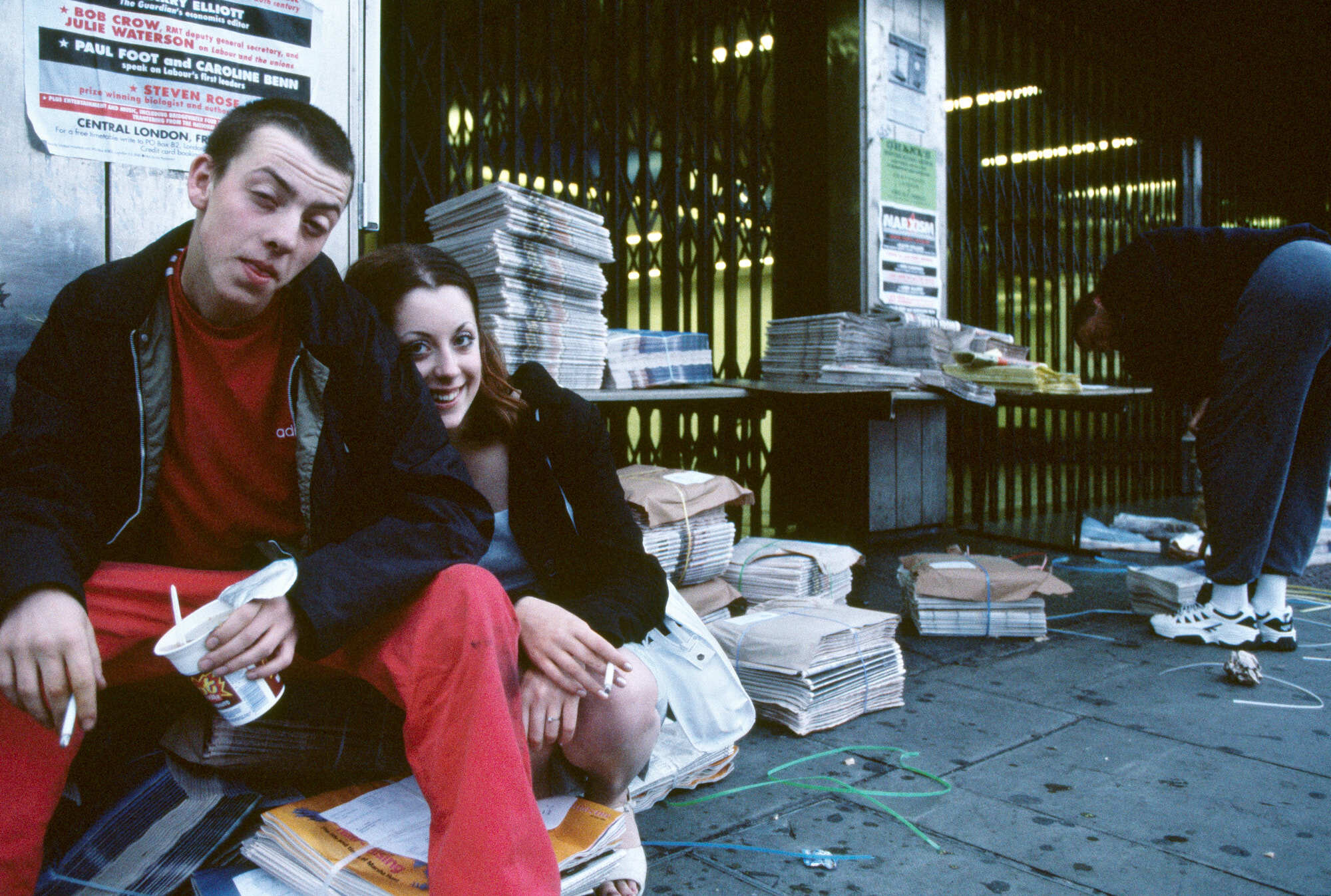 Couple sitting on ground in book-filled environment