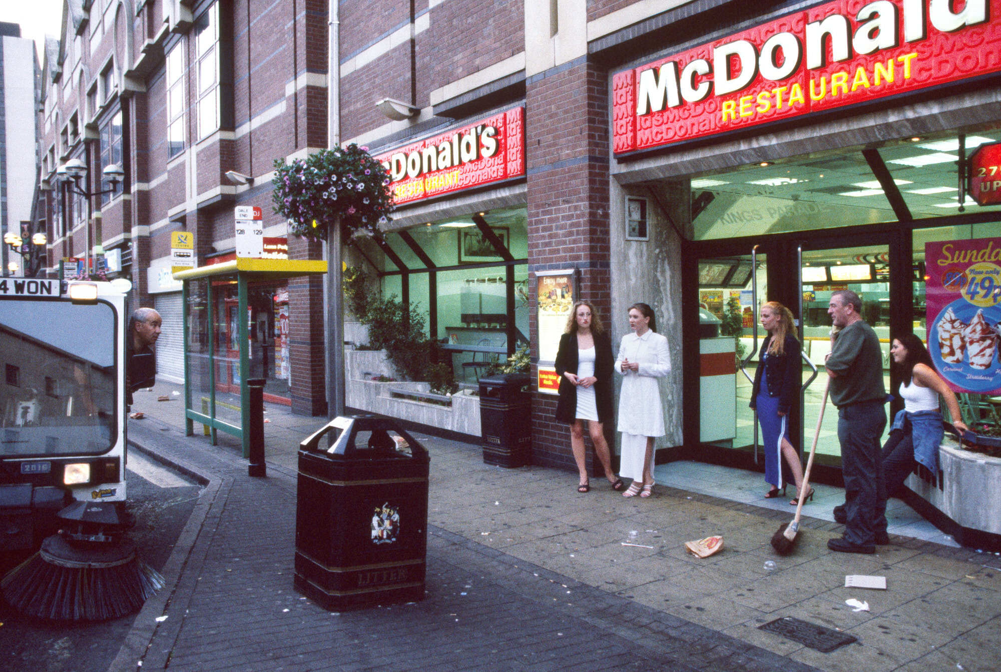 McDonald's restaurant on a city street with people standing outside.