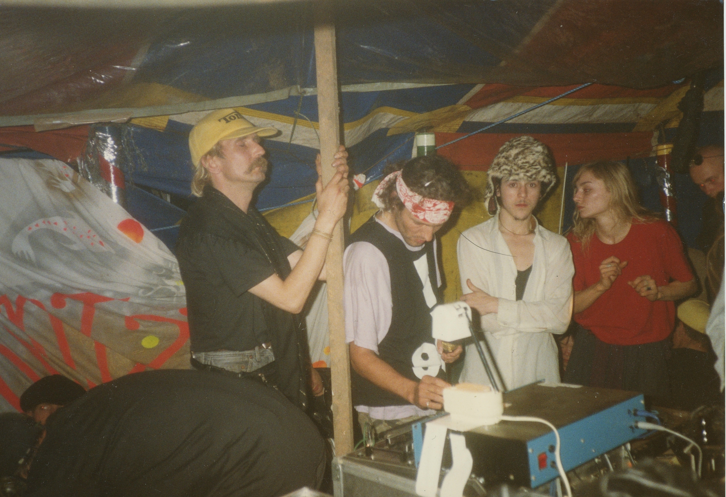 A group of people, some wearing hats, performing on a stage with musical instruments.