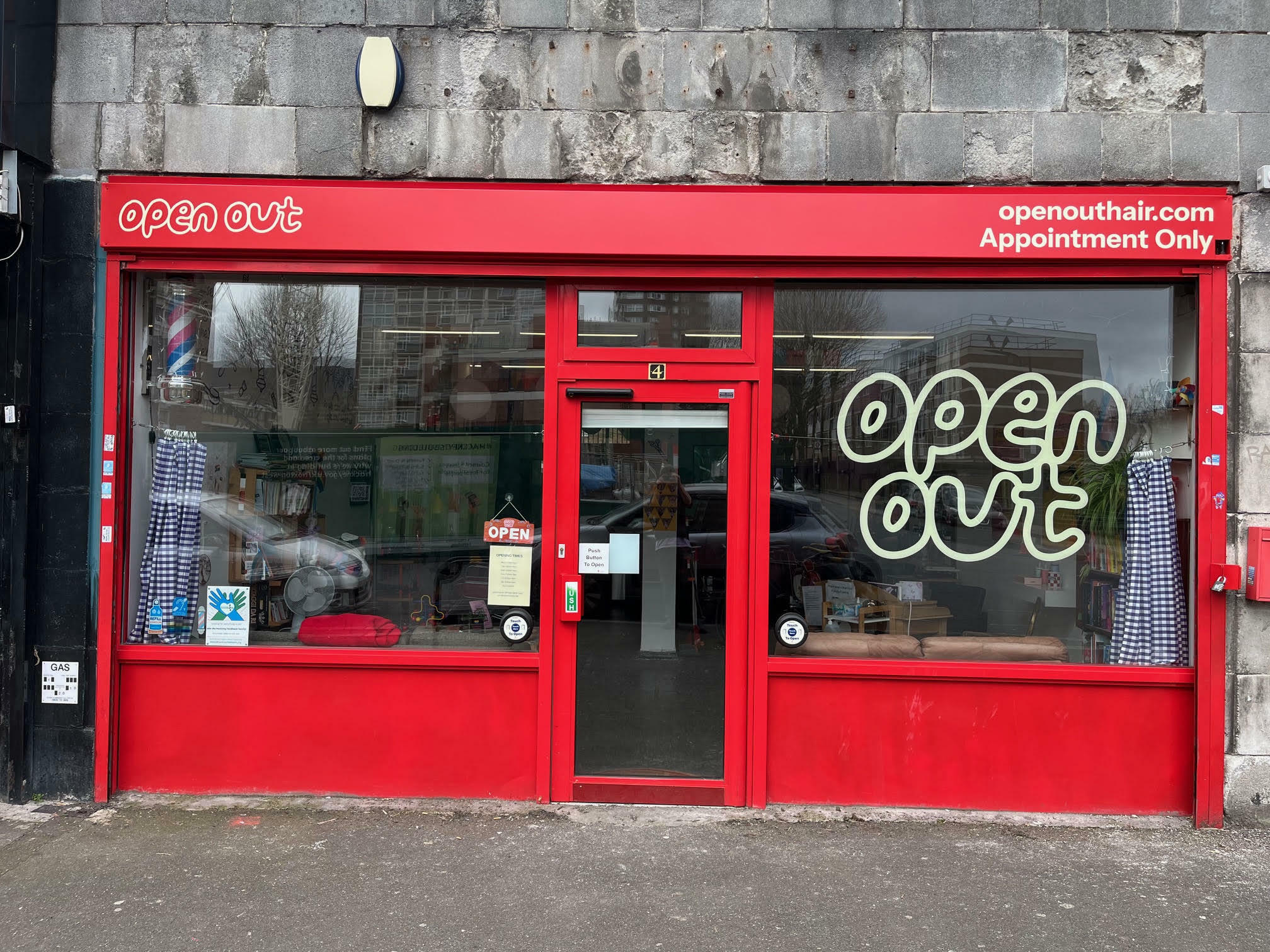 Red shop frontage with "Open Out" branding and appointment-only signage.