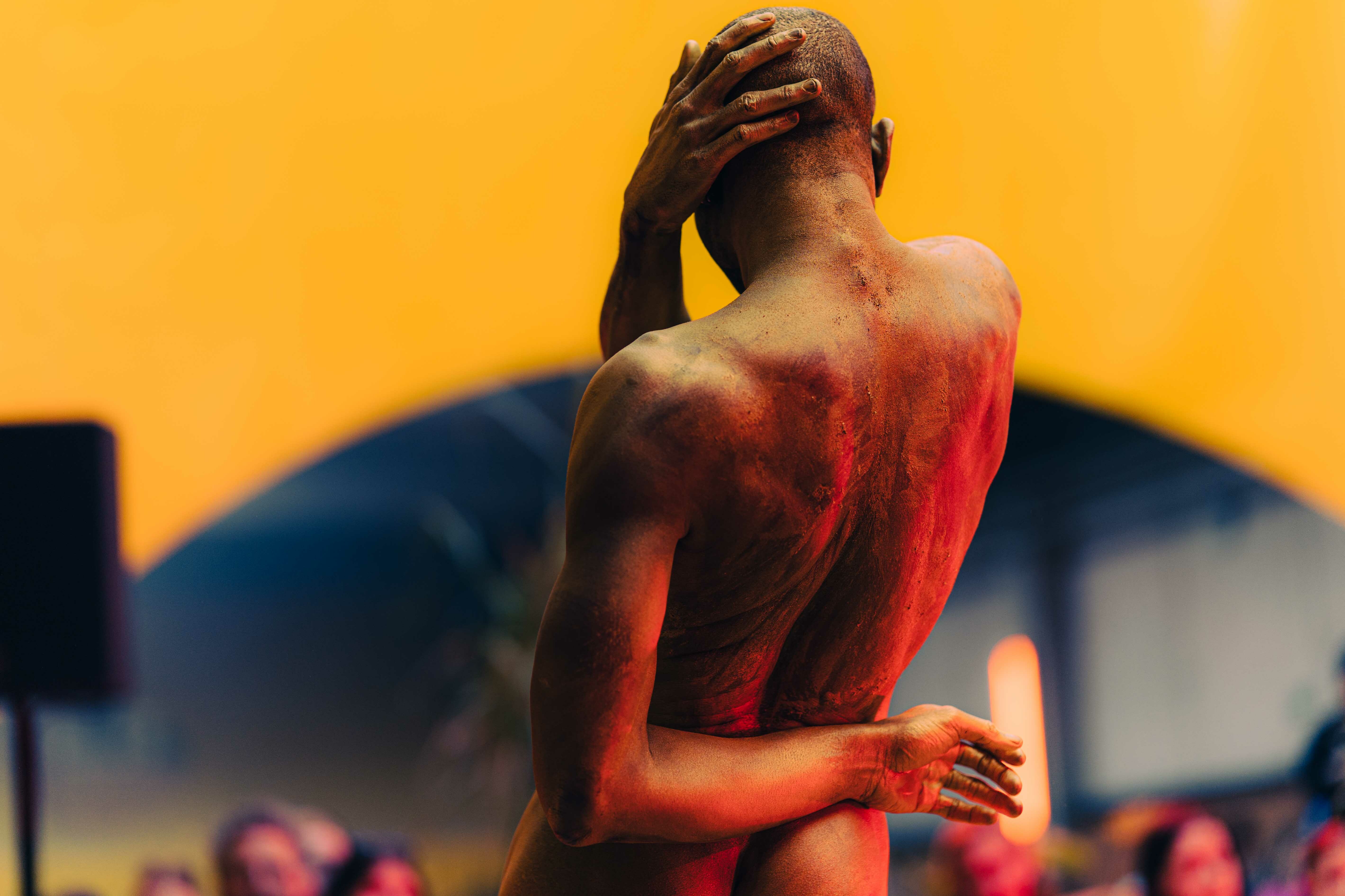 Figure of a person with exposed, reddened skin against a vibrant yellow background.