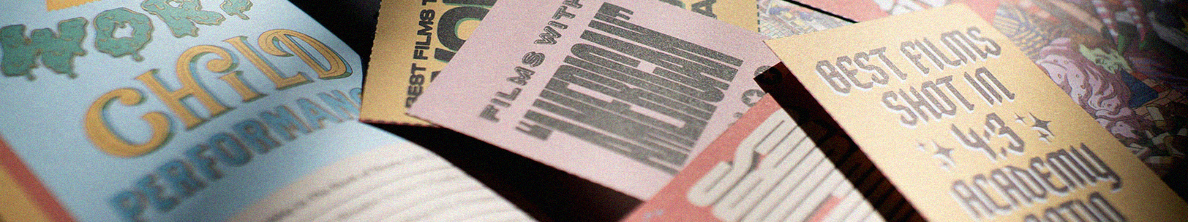 Multiple open magazines scattered at angles showing colourful pages with photography, text, and graphics in various layouts.