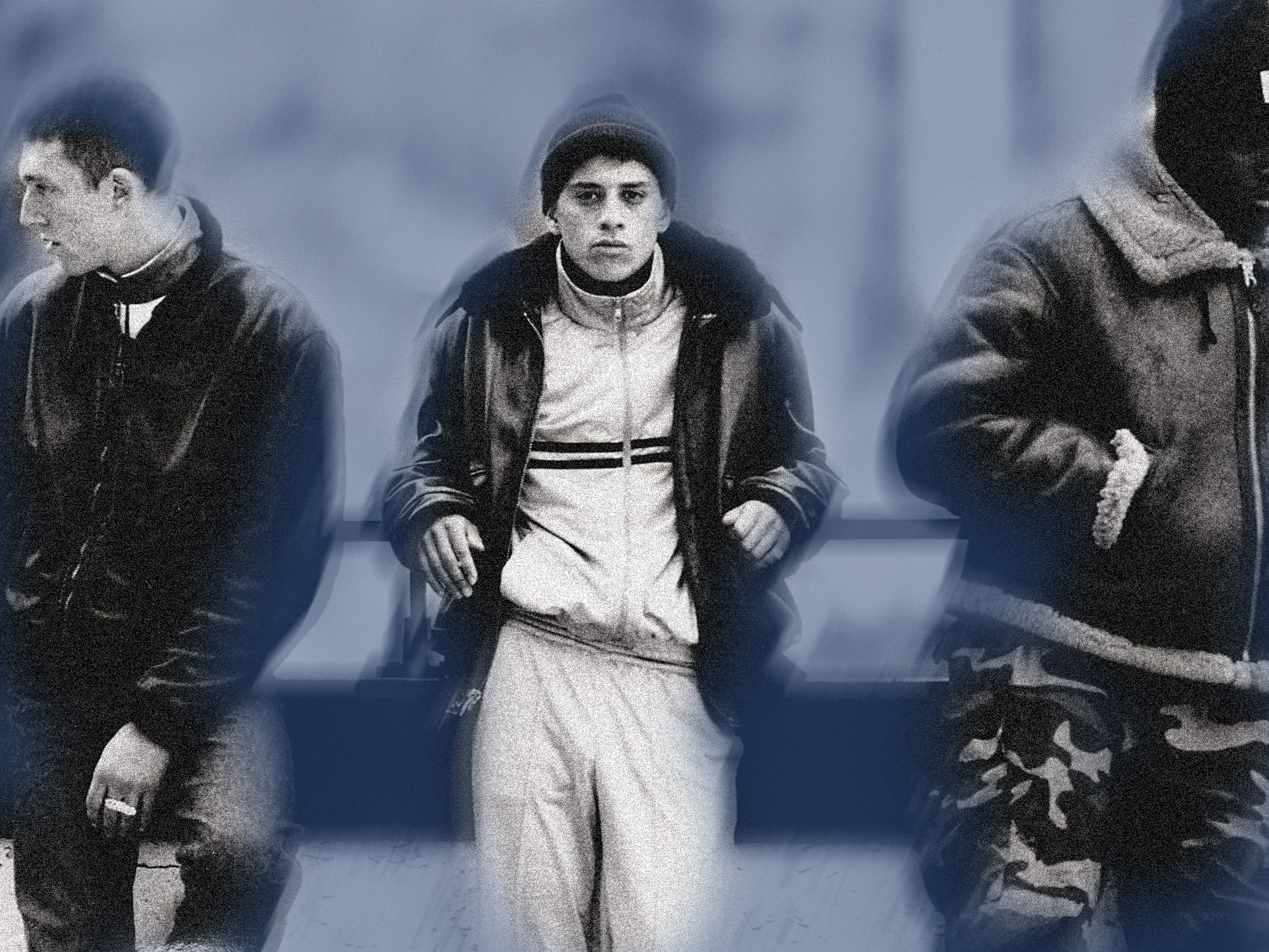 Three men in winter clothing walking, centre figure in white tracksuit and dark jacket, flanked by men in dark coats, blurred background.