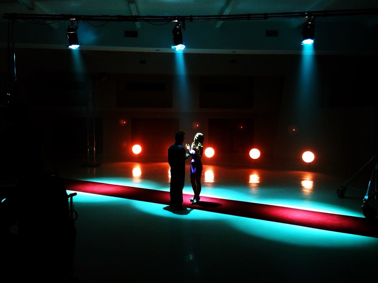 A moody shot from behind the scenes on CSI: Crime Scene Investigation, showing a couple in the centre of the frame with dramatic lighting.