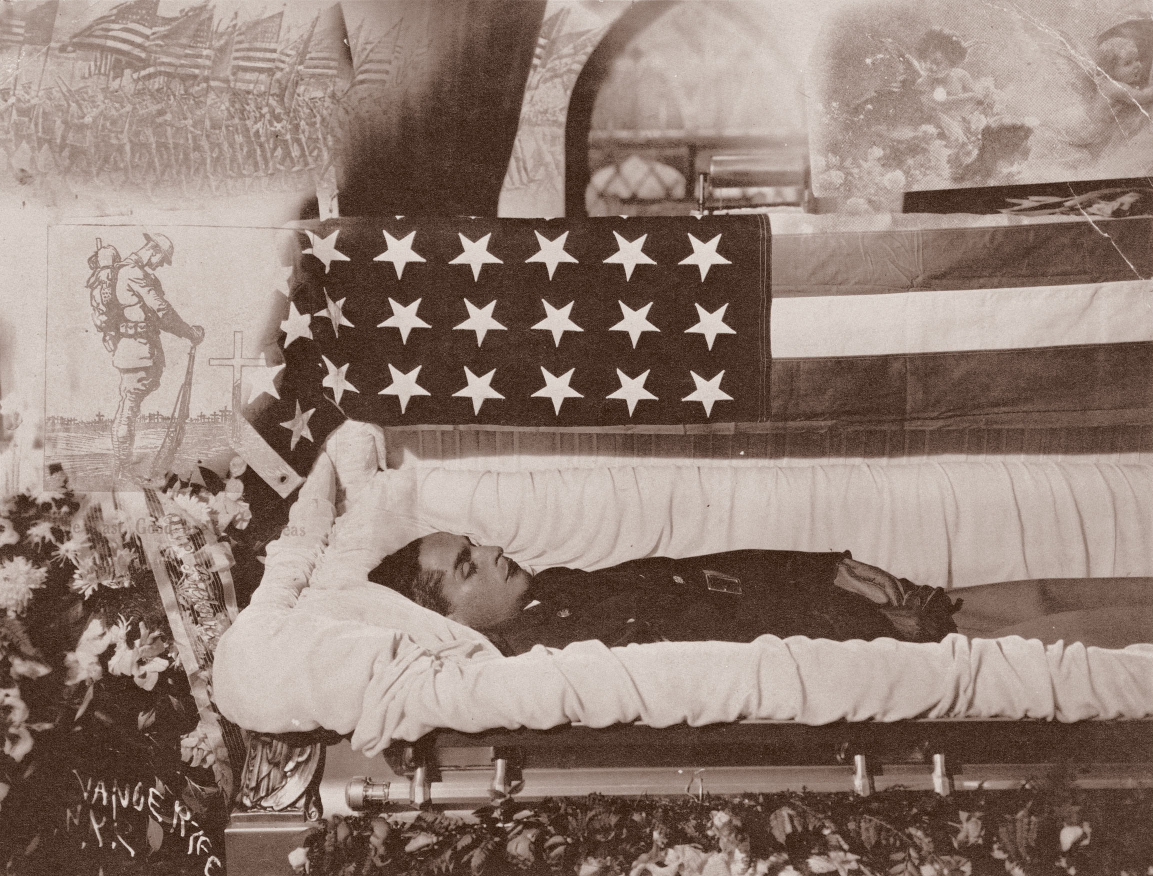 Black and white image showing a person lying in state in an open coffin draped with an American flag, surrounded by floral arrangements.