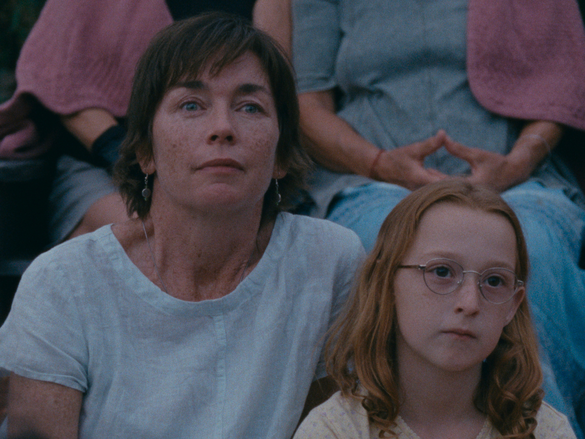 Older woman with dark hair and younger woman with red hair and glasses, both looking directly at the camera.