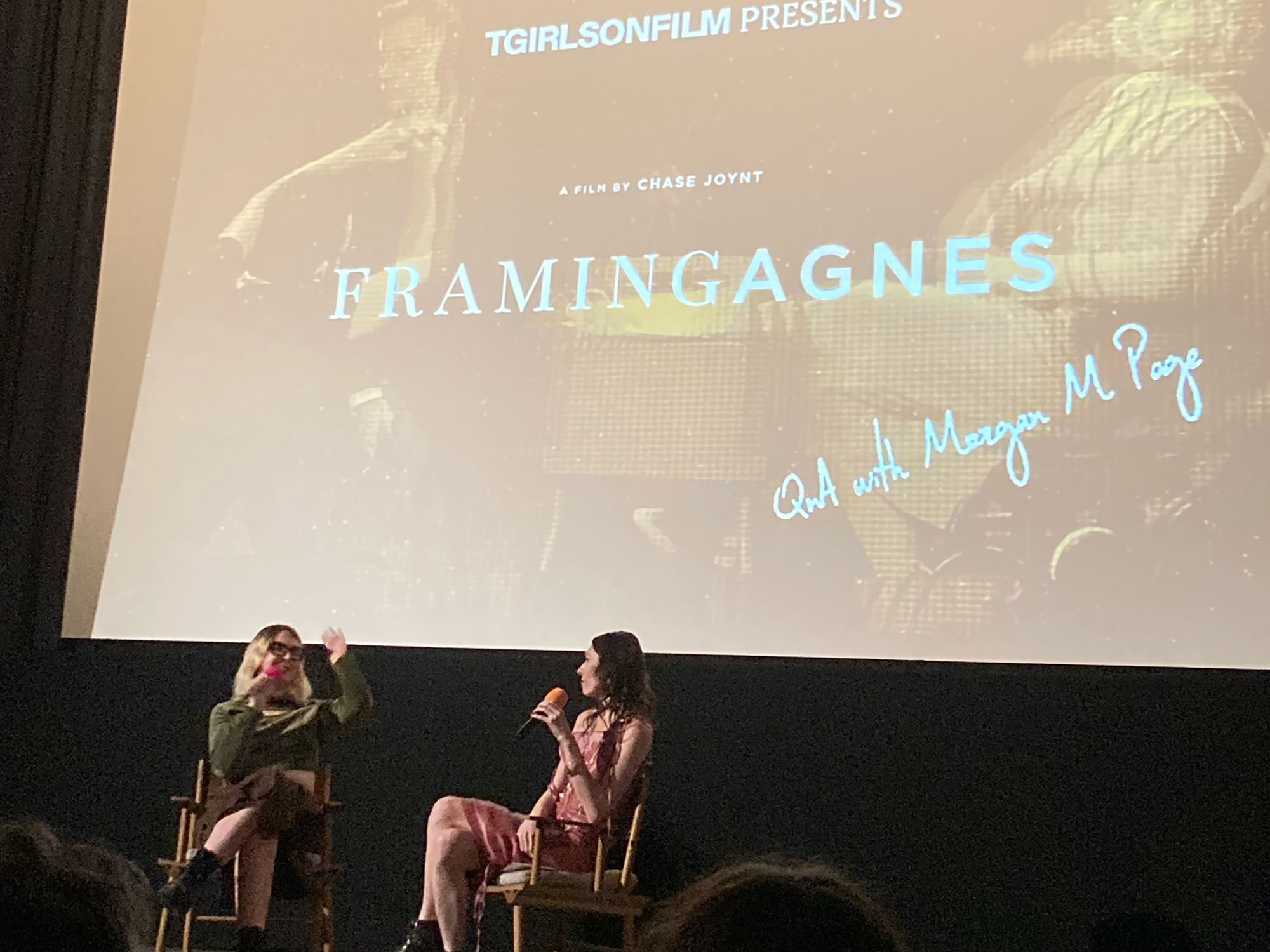 Large cinema screen displaying film title 'Framingagnes' with credits. Two women sitting on stage in front of the screen.
