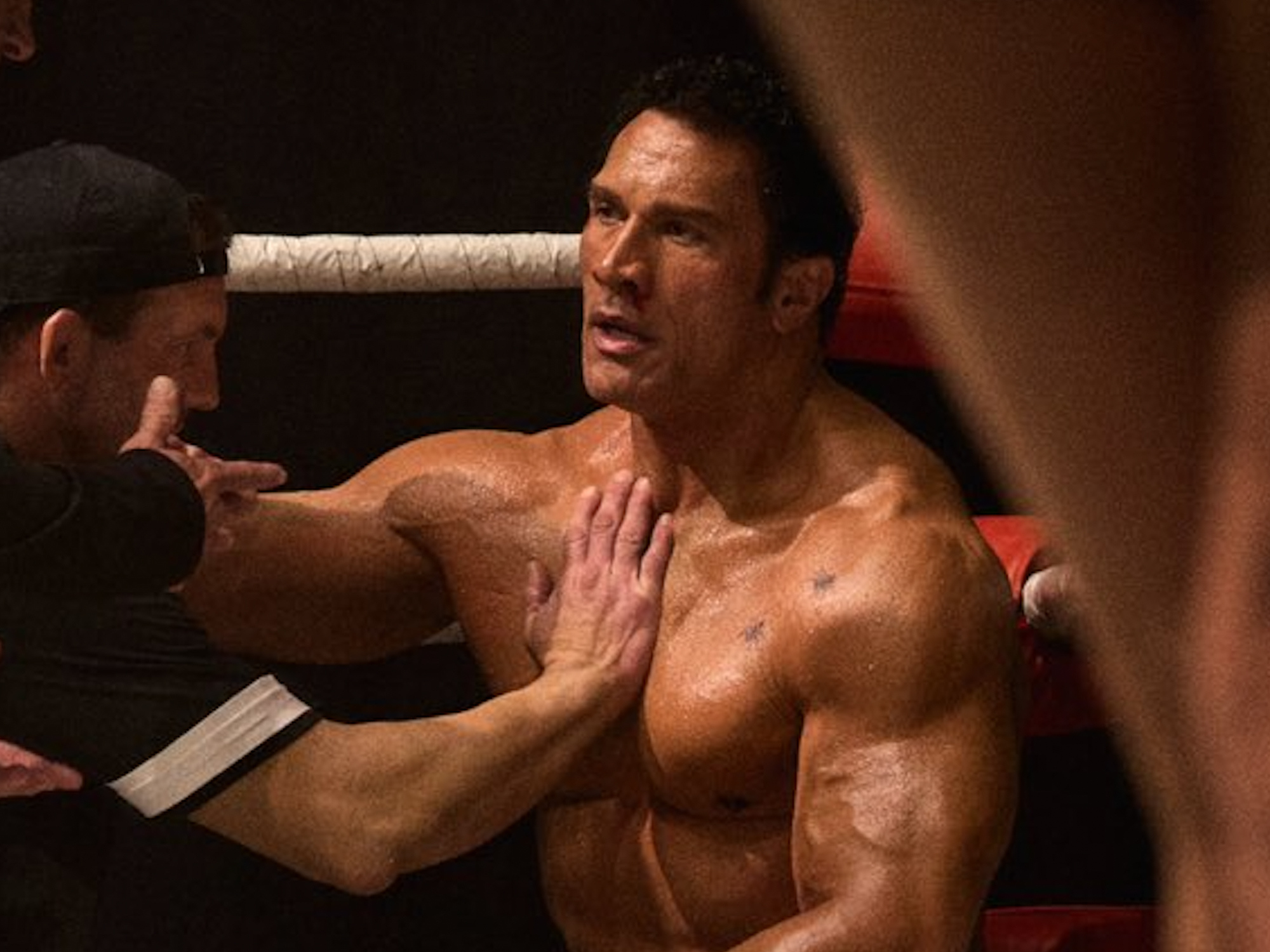 Muscular male figure in a boxing stance, shirtless, with intense facial expression.