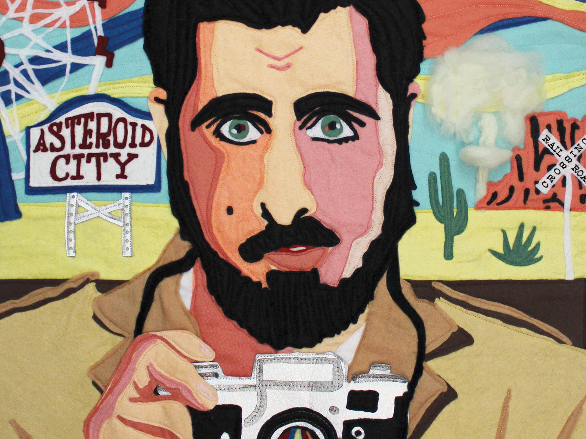 Colourful painting of a bearded man holding a camera, with a desert landscape and "Asteroid City" sign in the background.
