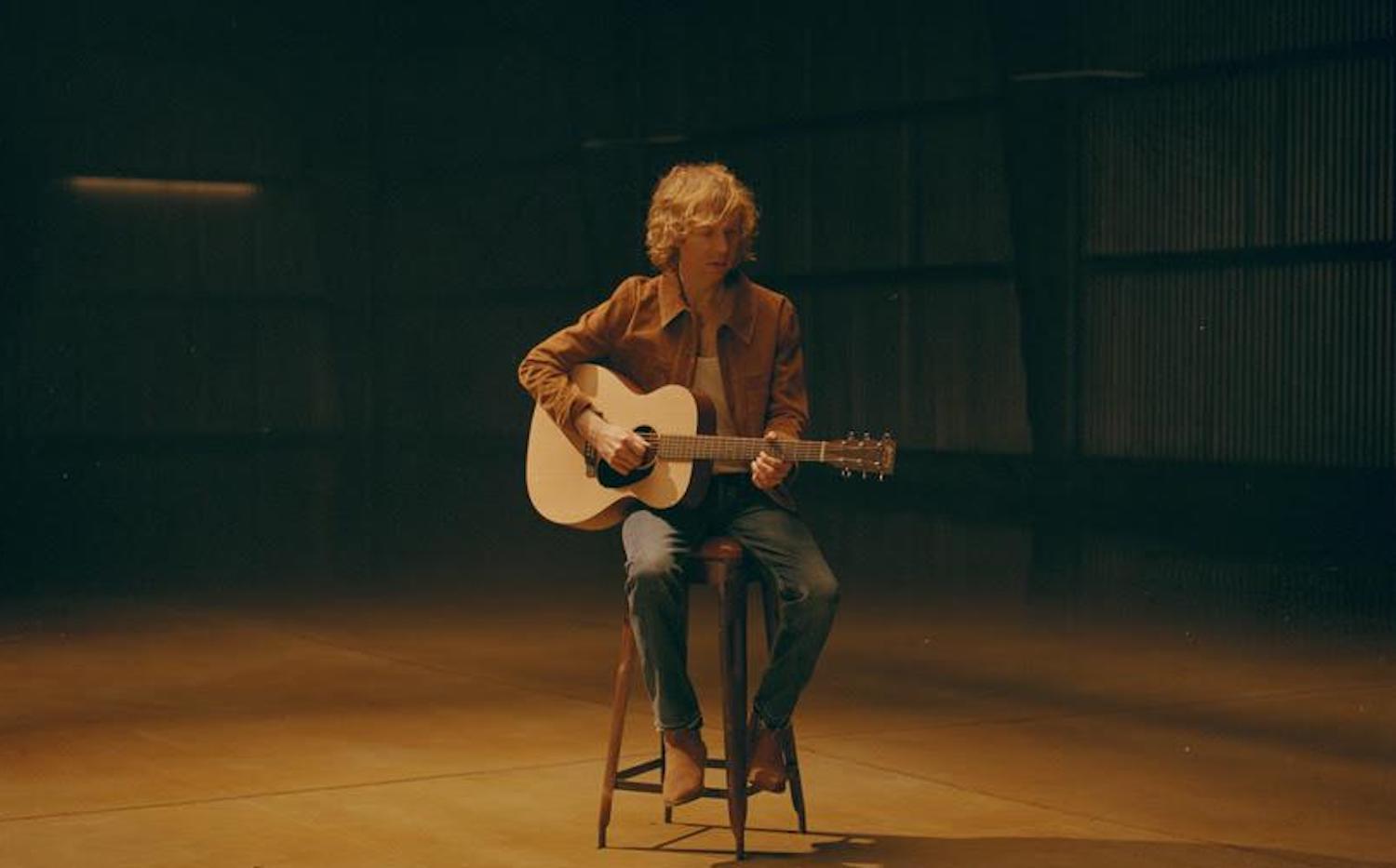 Beck on stool with guitar for cover of Neil Young's "Old Man"