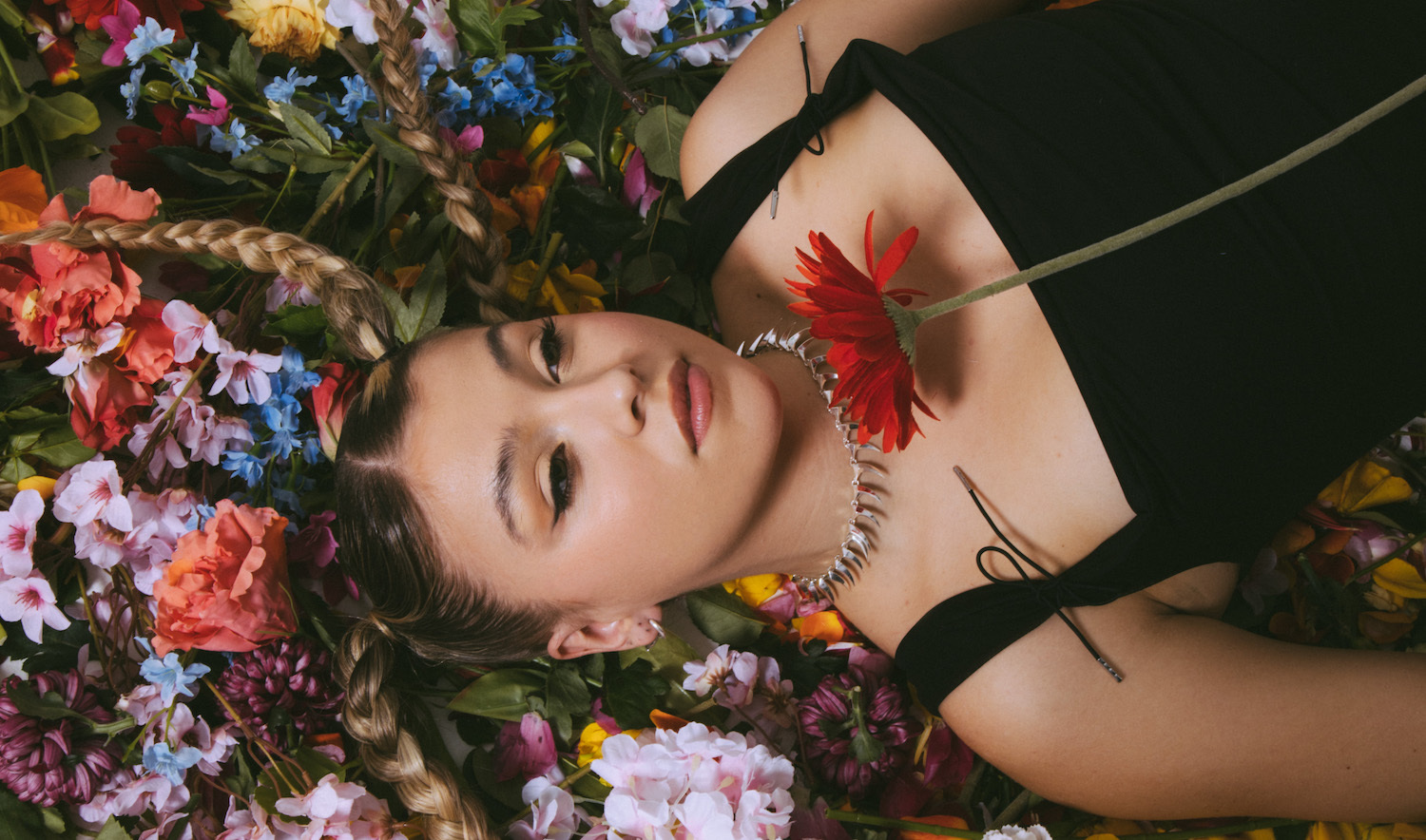 Caity Baser lying on flowers