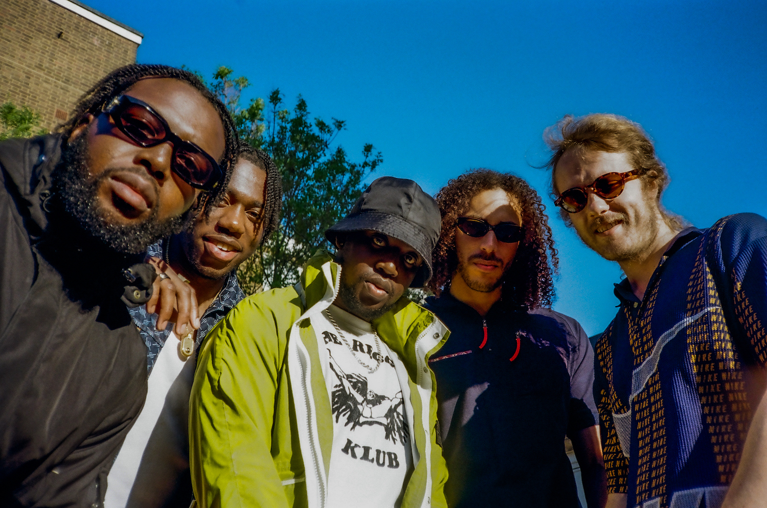 Ezra Collective group shot outdoor blue sky