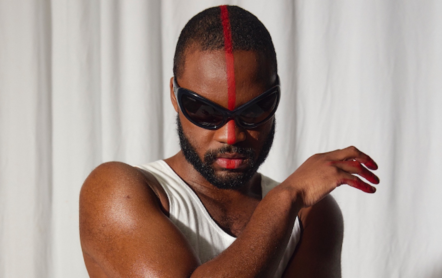 Genesis Owusu wearing sunglasses with red line down face