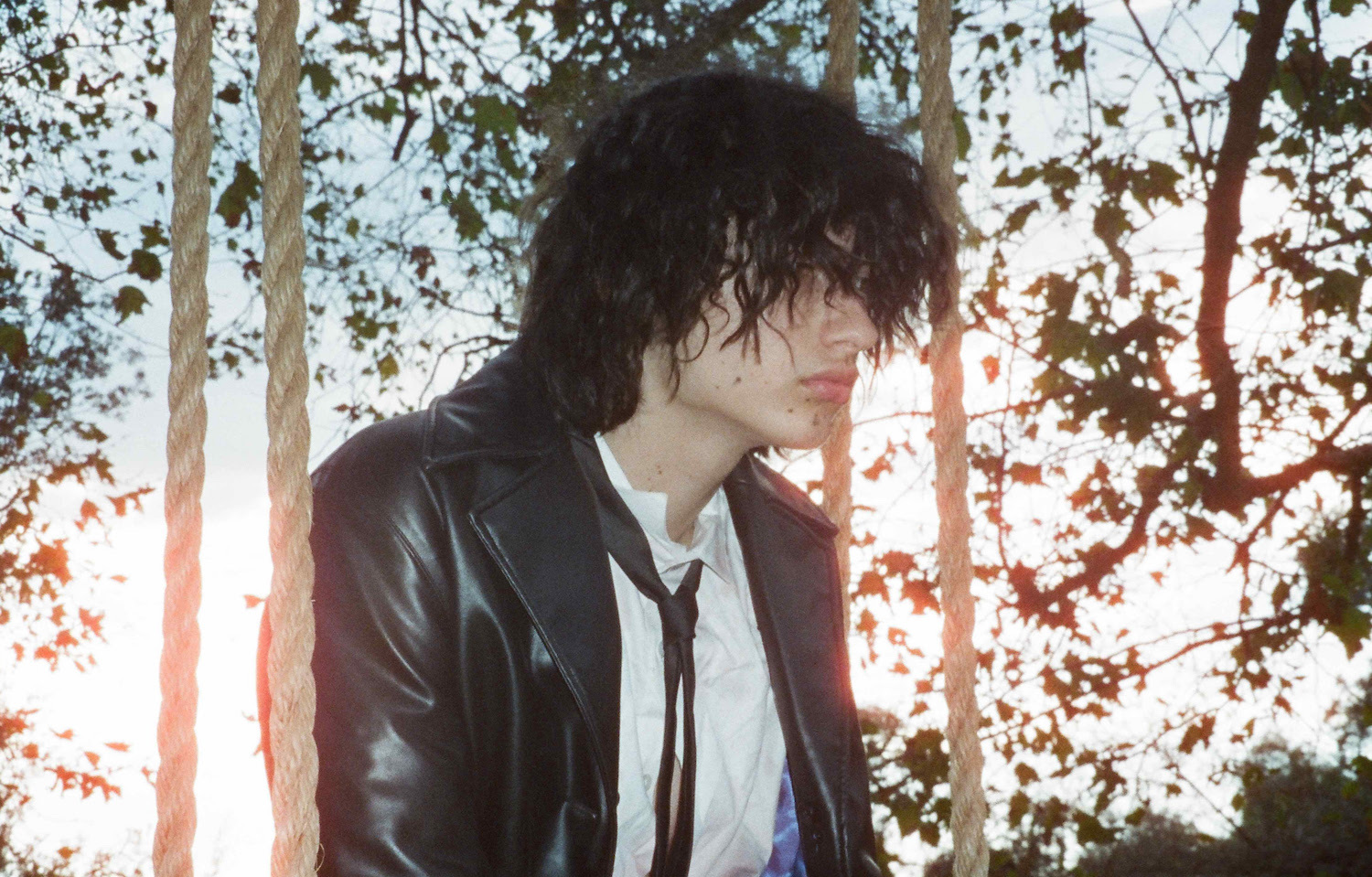 Glaive on swing in shirt and tie for "three wheels and it still drives!"