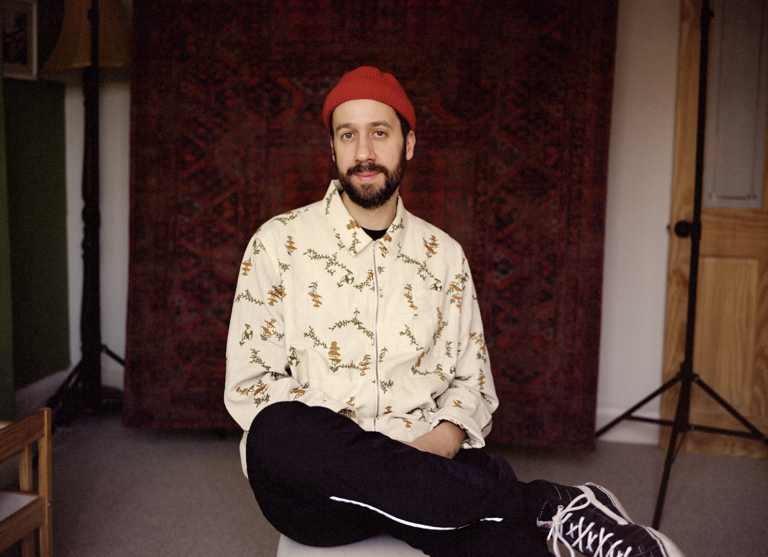 Gold Panda 2022 seat red hat beige shirt