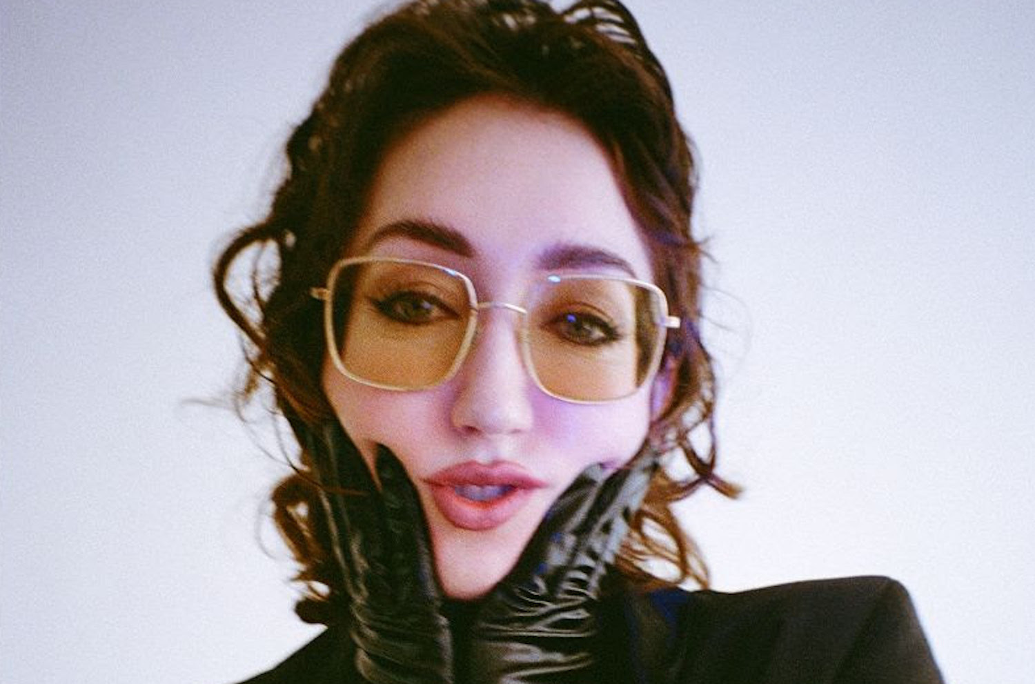 Jessica Winter black gloves holding face