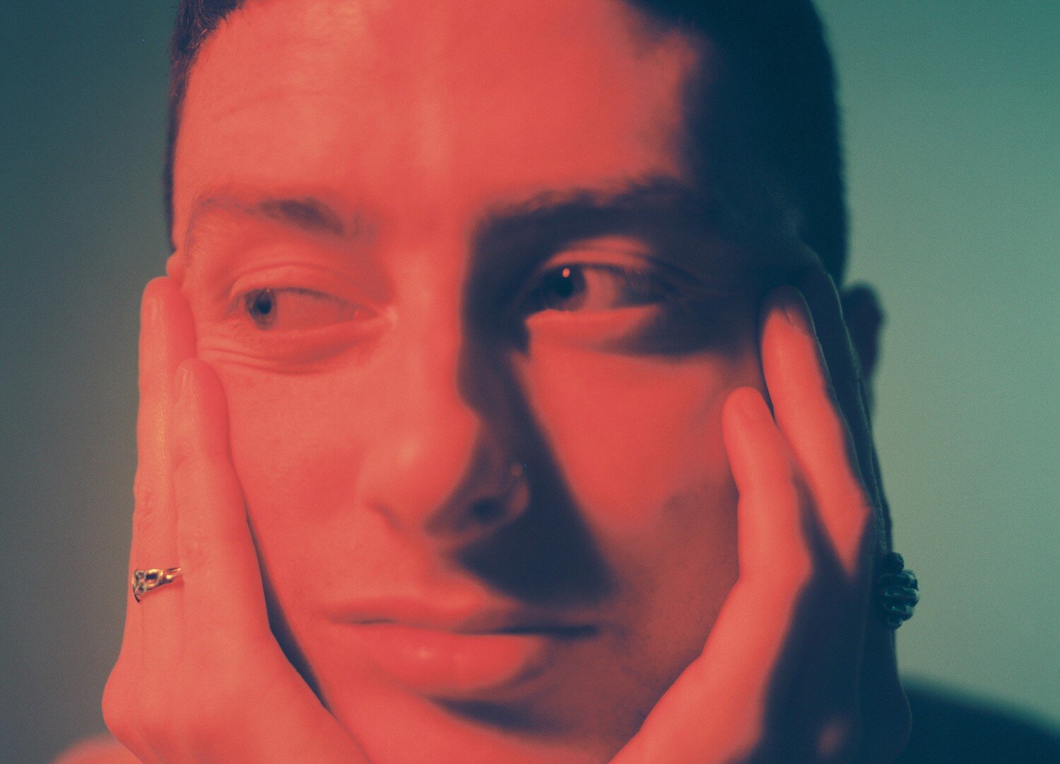 Joesef resting face in hands with red light