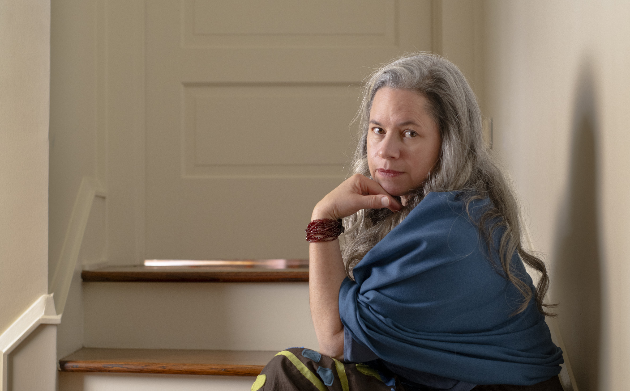 Natalie Merchant sitting on some stairs outside of a childs bedroom