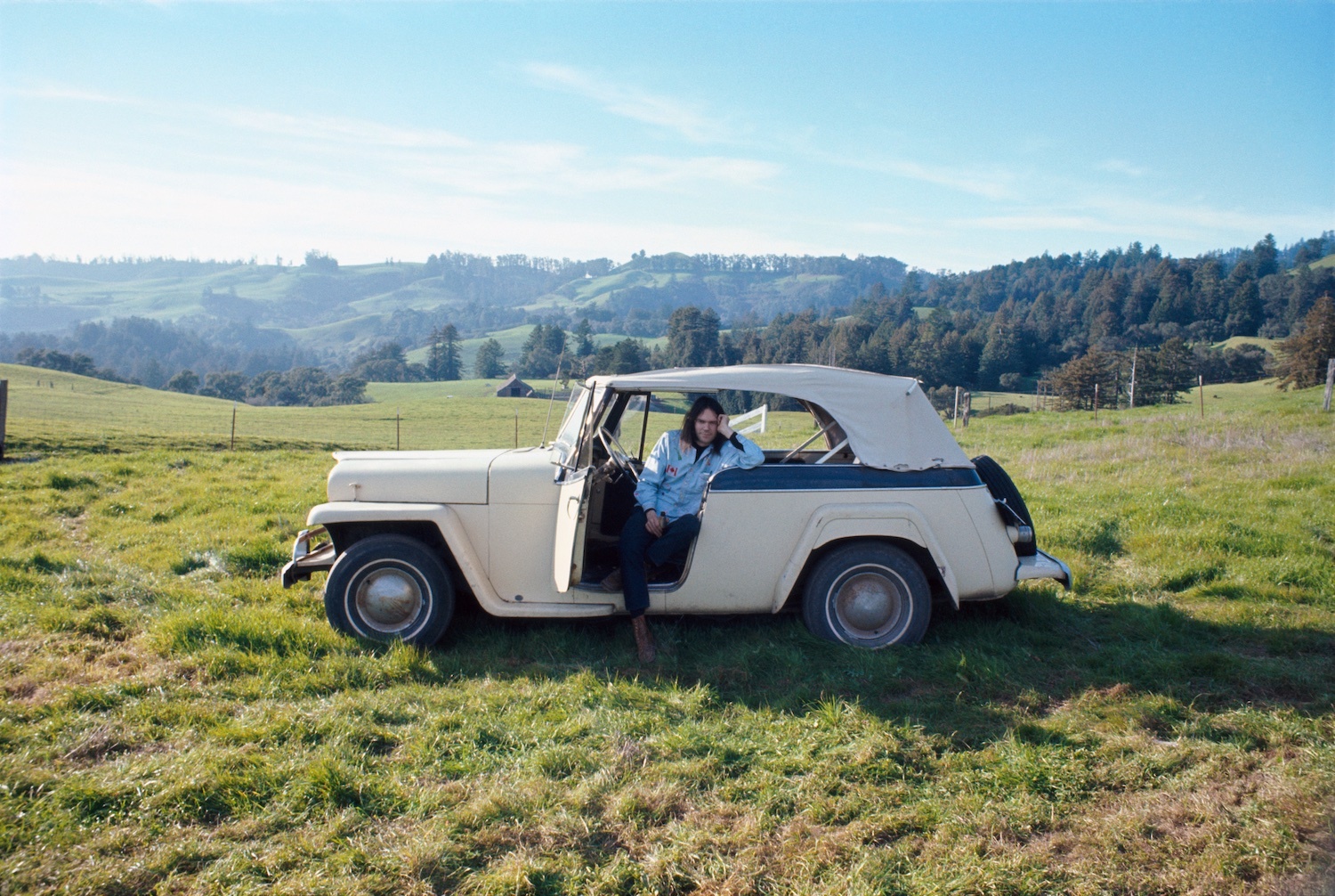 Neil Young sat in car in field