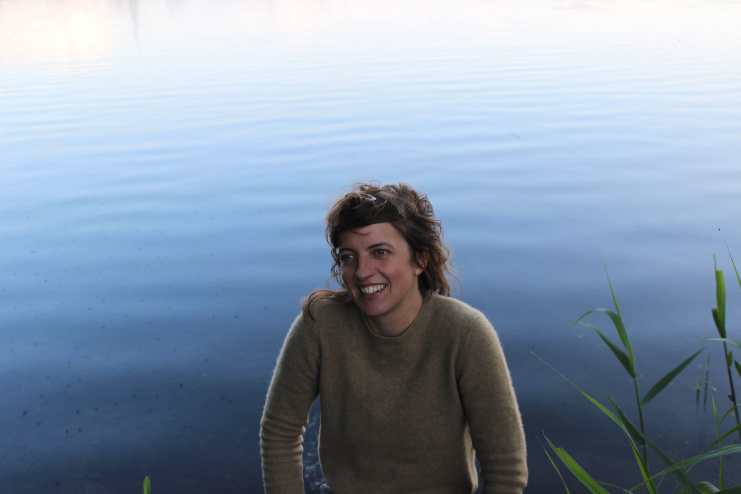 Rozi Plain smiling at edge of lake for PRIZE album announce