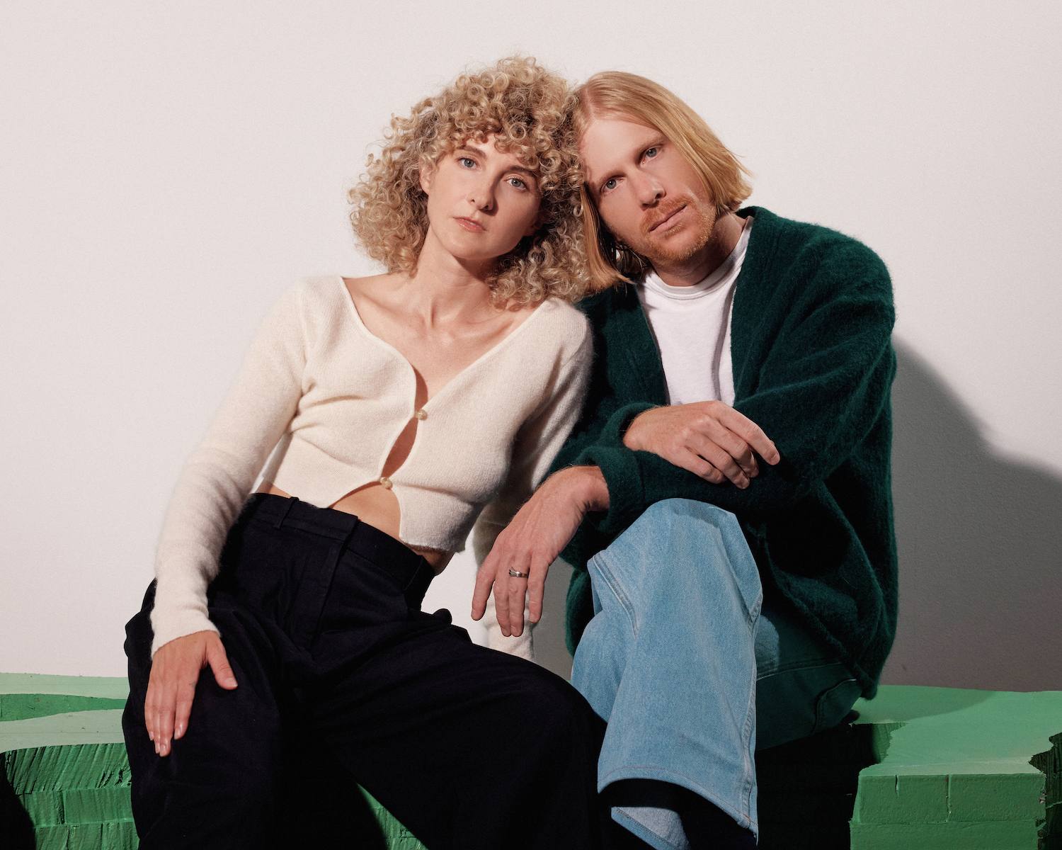 Tennis leaning together on green seat