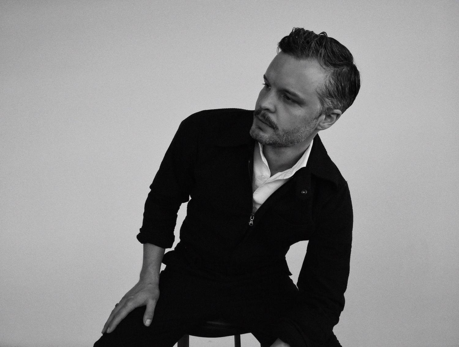 The Tallest Man On Earth sitting on stool monochrome