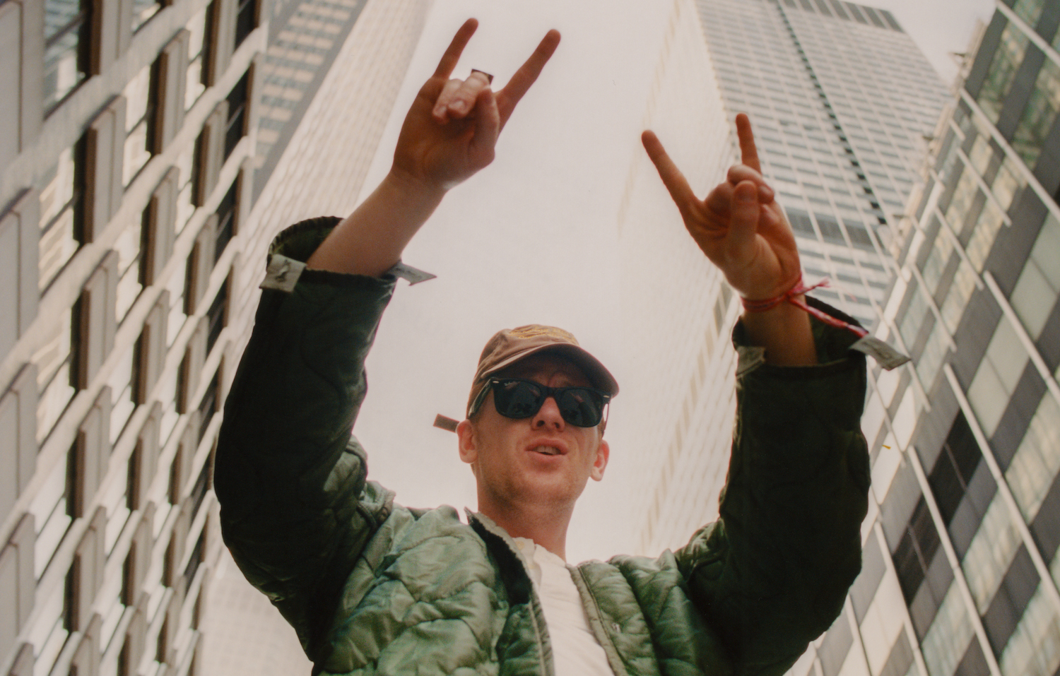 Willie J Healey rock on low angle with skyscrapers