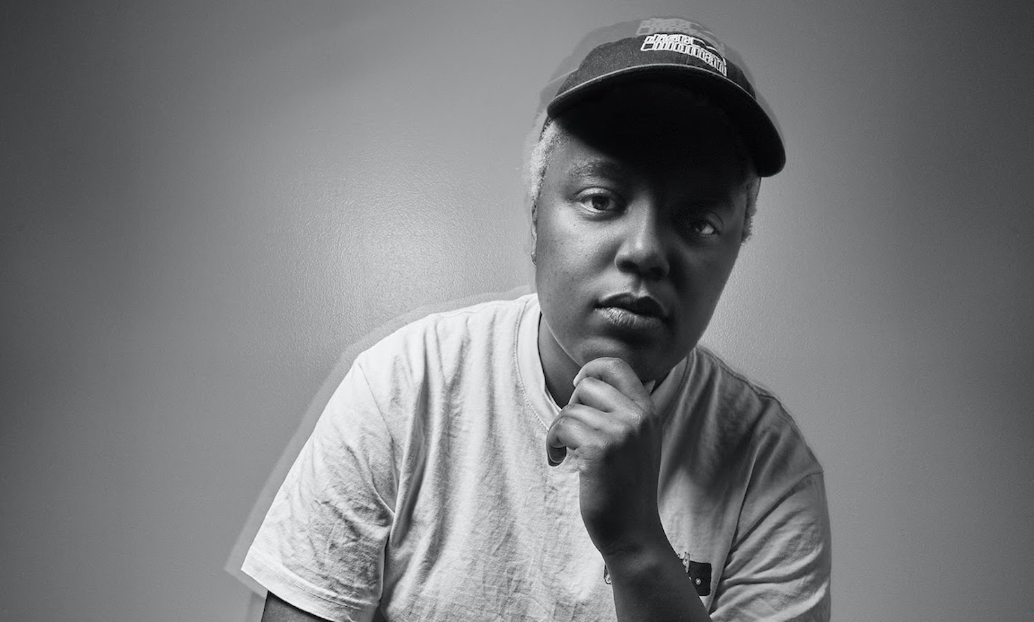 Loraine James sitting with hand on chin in monochrome