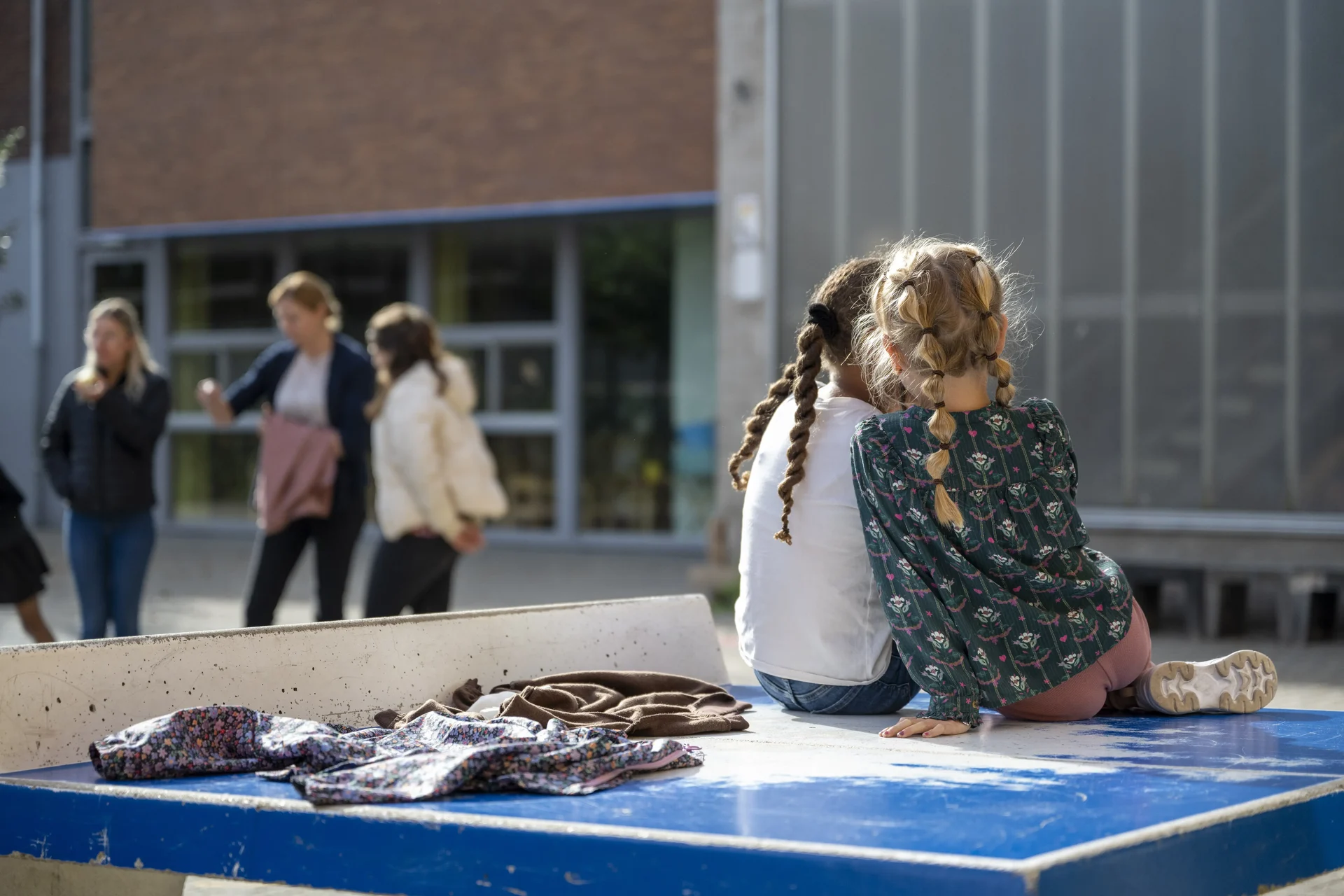 Two Children Whispering In Table