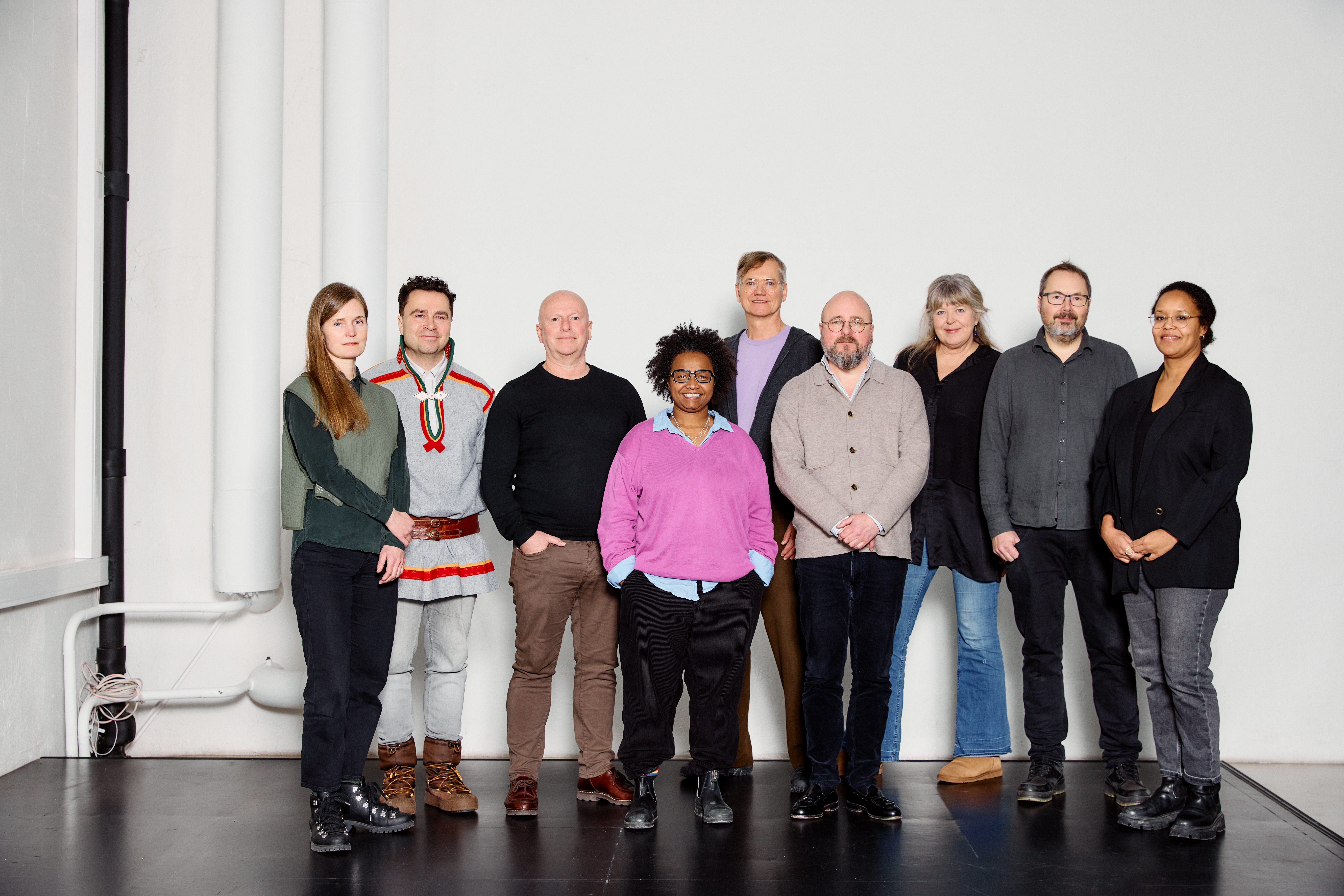 Ni personer fra Kulturrådet står samlet innendørs og smiler mot kameraet.