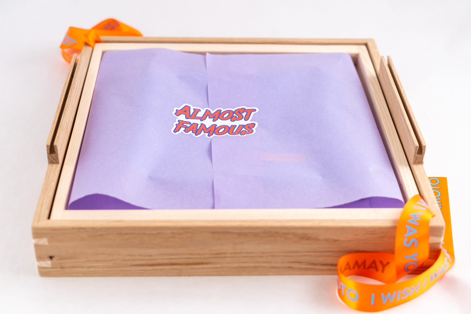 Lys treboks med lilla silkepapir og teksten "almost famous".