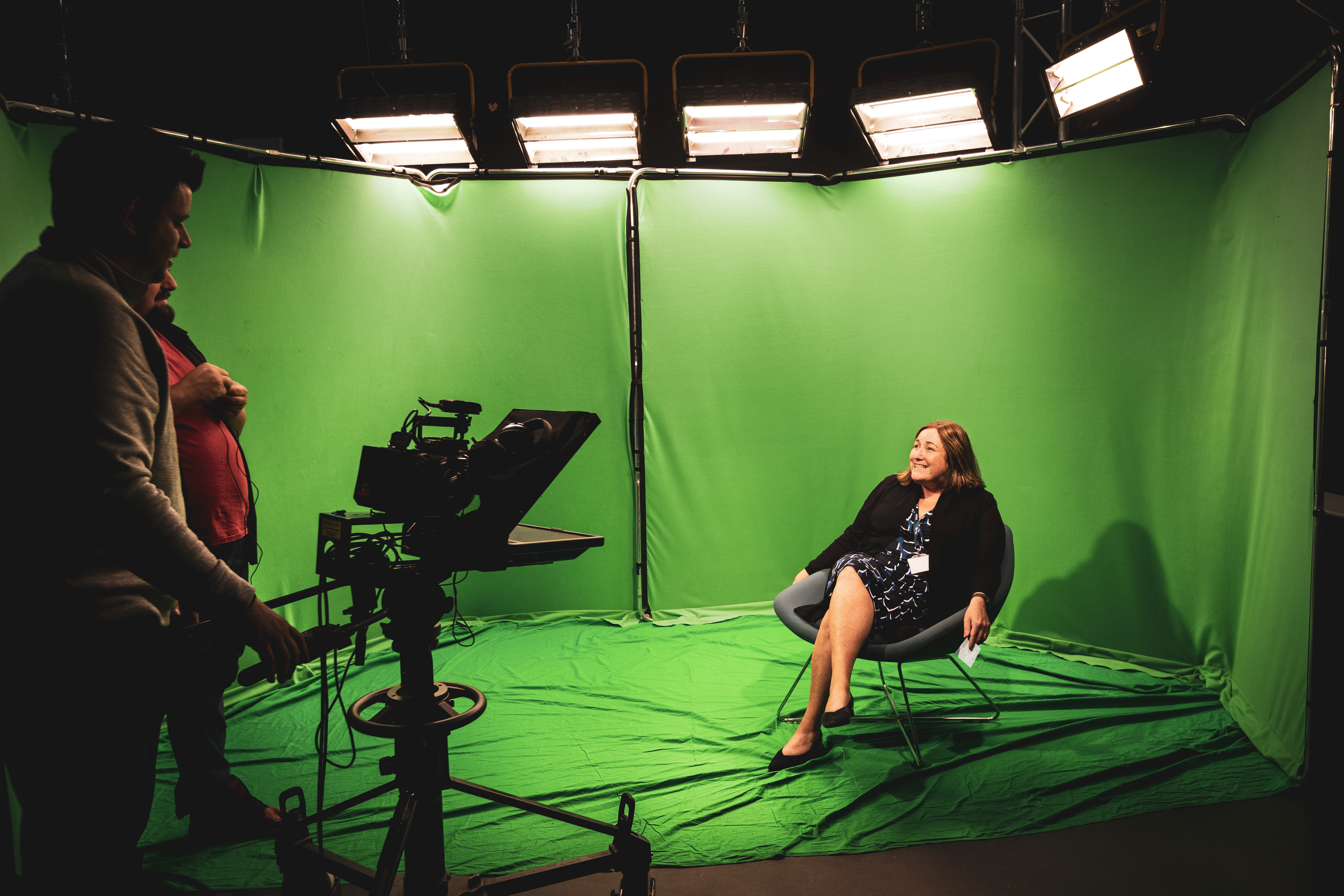 Joanne Terry-Marchant Reading from a Prompter whilst sitting in front of a Green Screen.
