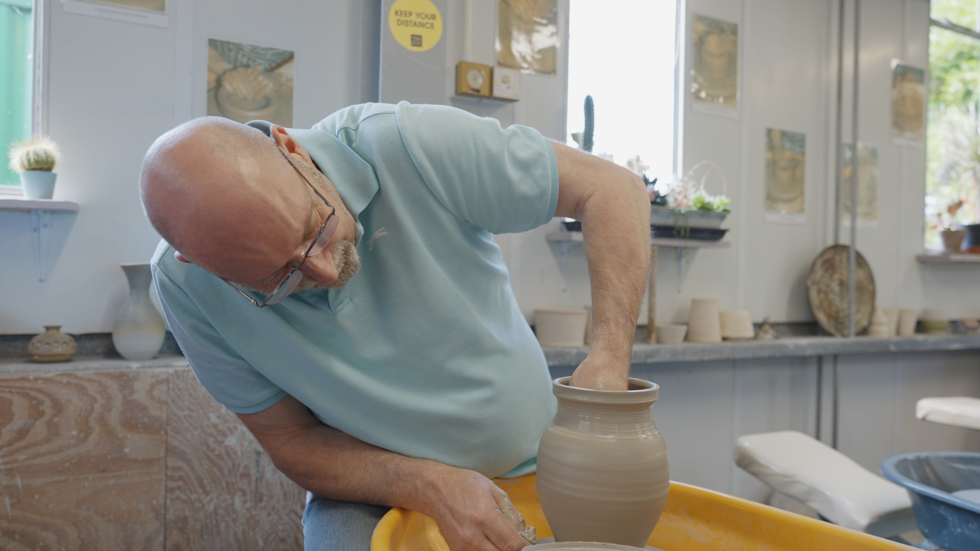Man molding a vase out of clay.