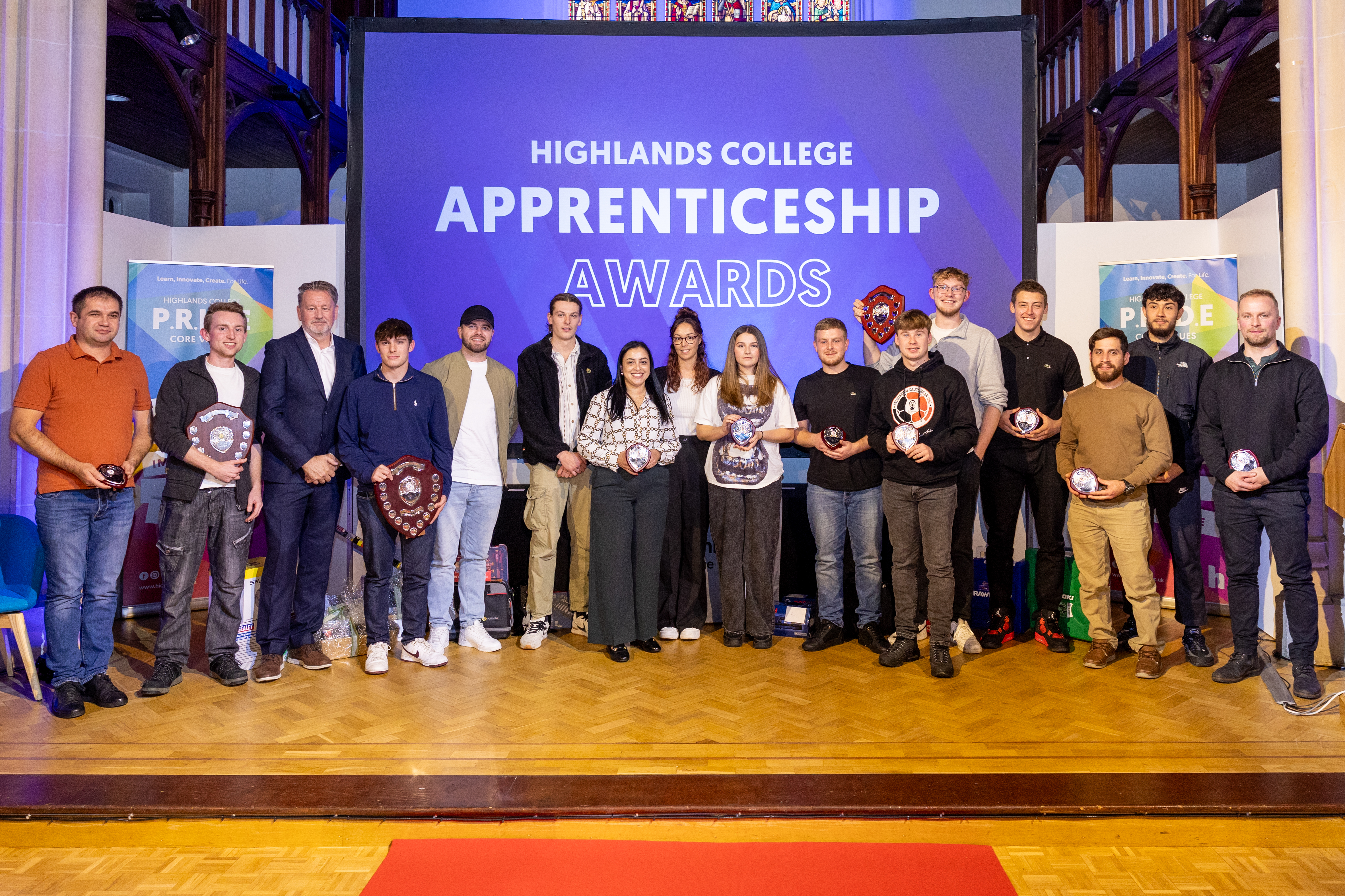 A group photo of apprentices all holding awards and smiling towards the camera.
