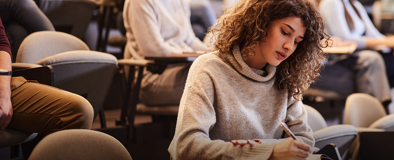 Student in a Classroom Taking Notes