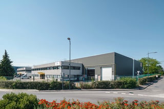 Site logistique Montea au Mesnil Amelot, France : entrepôt gris avec quai de chargement et bloc de bureaux de deux étages attenant