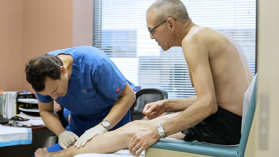 Doctor Eddie Fernandez performs a painless physical exam while patient is sitting spanish