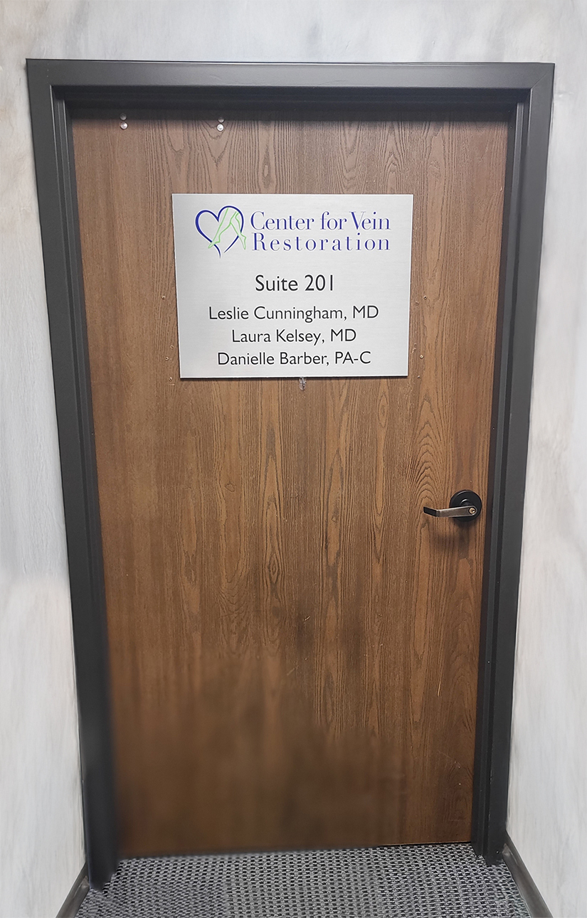 Center for Vein Restoration Lansing Michigan Suite 201 door sign with Dr. Leslie Cunningham, Dr. Laura Kelsey, and Danielle Barber PA-C