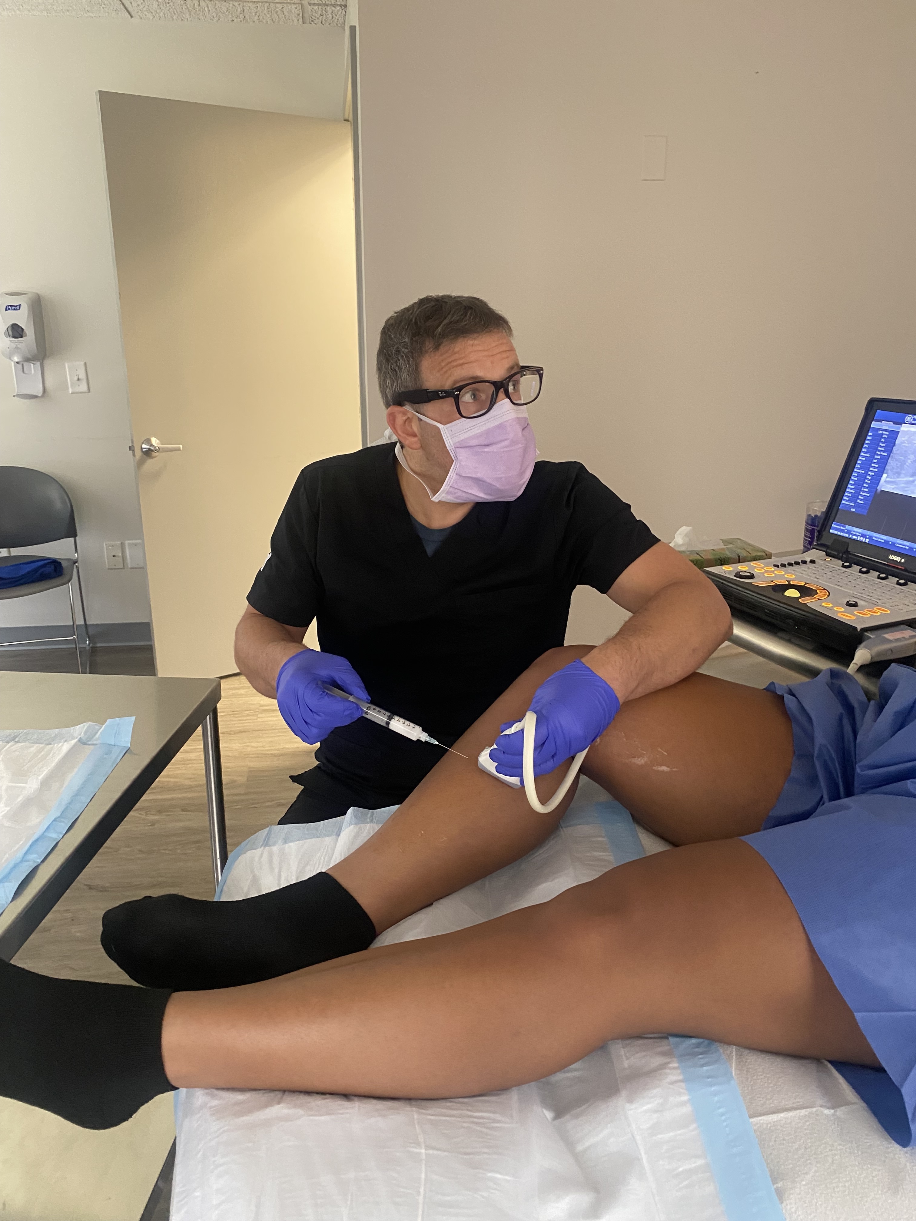 Foto interior de la sede de South Windsor, CT de Center for Vein Restoration que muestra al doctor con un paciente