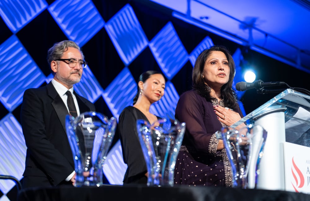 ALC's executive team members stand on the stage at the organization's 51st anniversary gala.