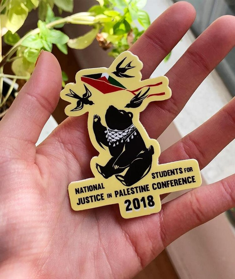 A sticker of a bear wearing a keffiyeh scarf, that reads "NSJP conference UCLA 2018"