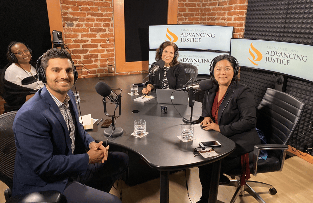 ALC staff members and reporters sit around a table with microphones. The group is recording a podcast interview about ALC's policy priorities.